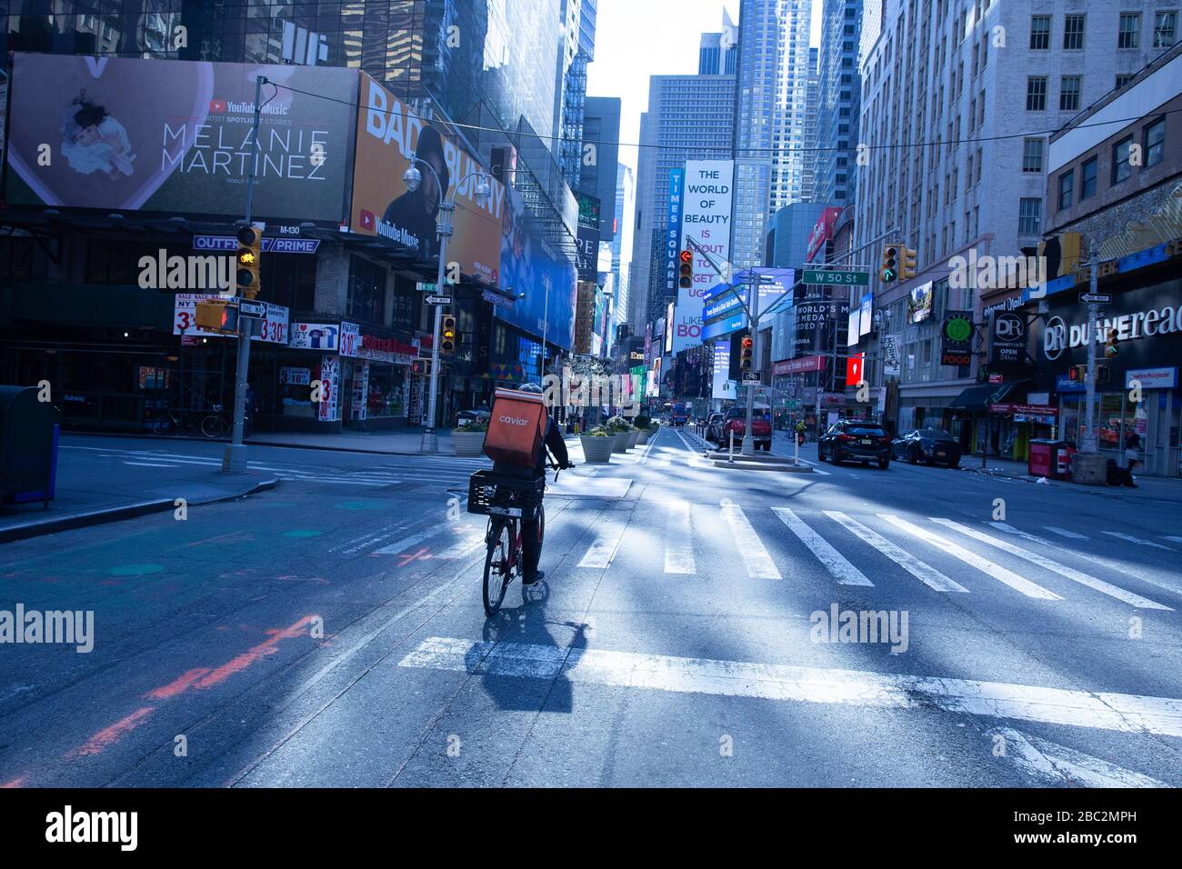 Empty Times Square, food delivery worker guidare giù Broadway NO traffico a metà giorno 30 marzo 2020 durante la pandemia di coronavirus Foto Stock