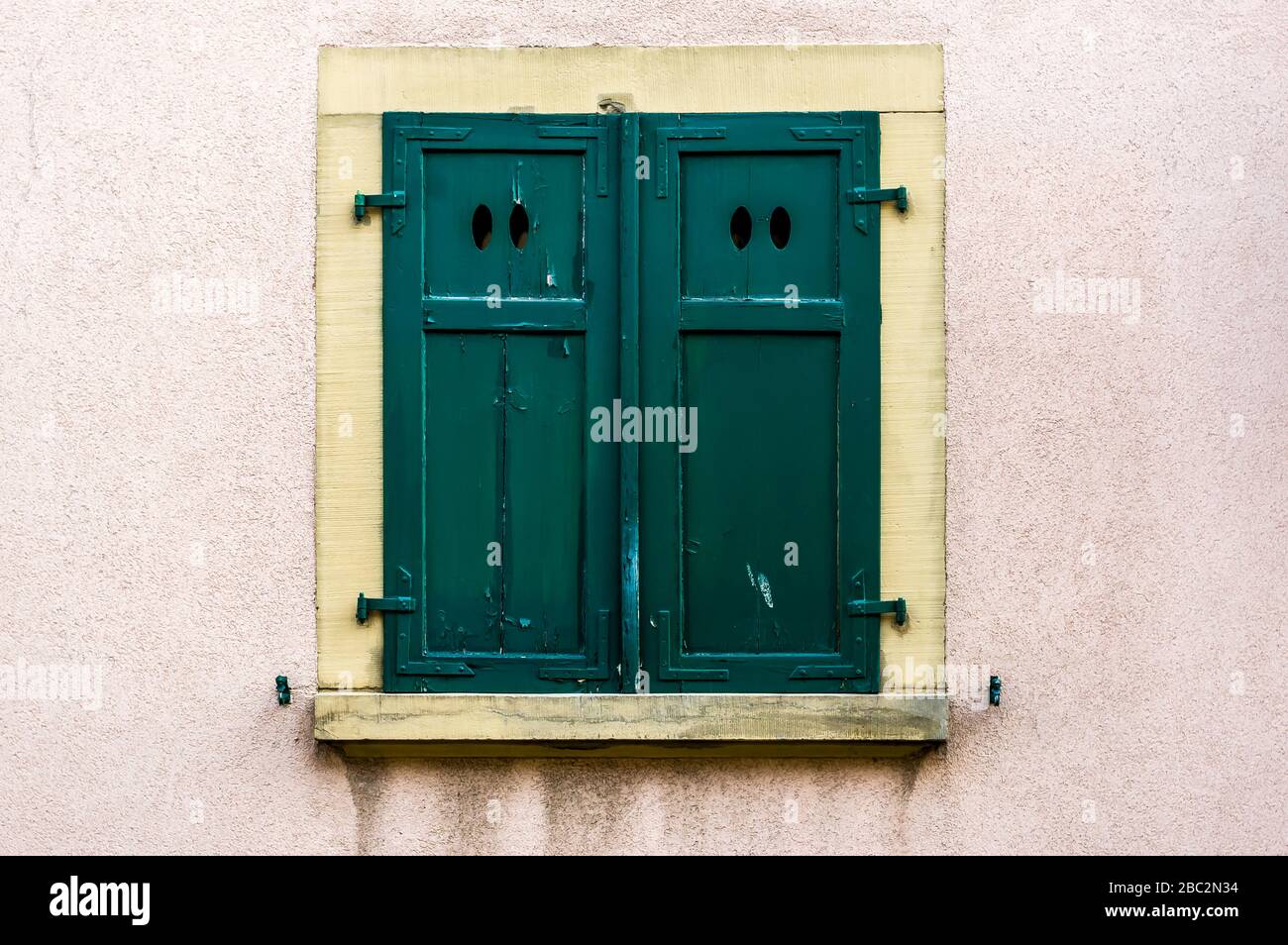 Facciata della casa con serranda verde in legno chiuso con 4 aperture ovali di luce Foto Stock