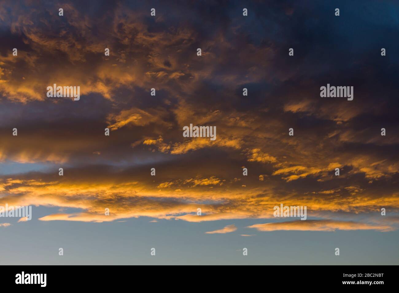 Cielo drammatico nube con nuvole di pioggia scura e nuvole luminose illuminate dal sole basso, incandescente nella sera bagliore prima e dopo una tempesta in Foto Stock