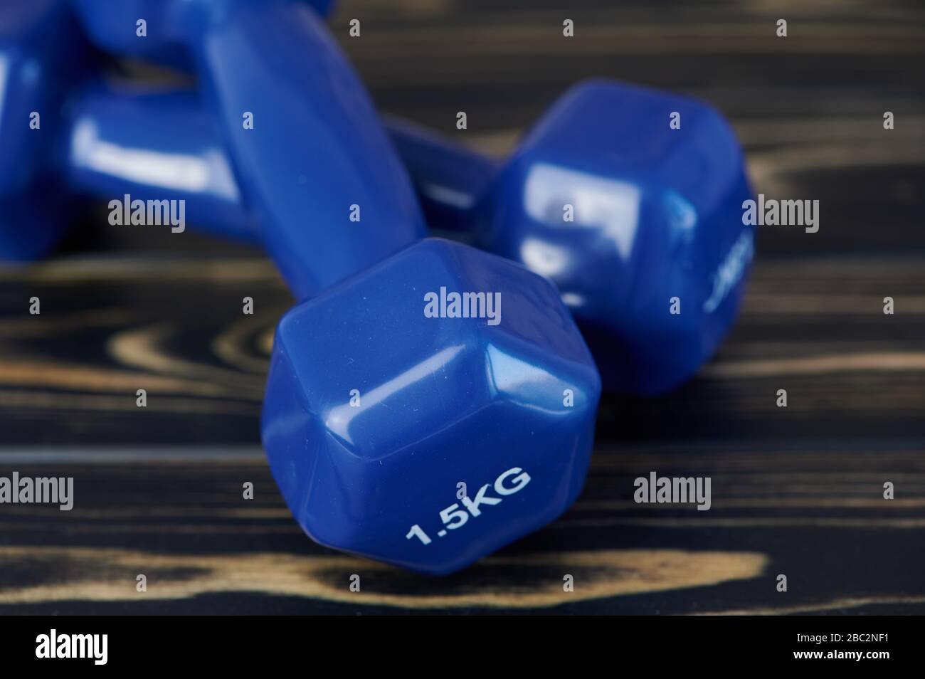 primo piano di pesi a mano blu sulla superficie di legno Foto Stock