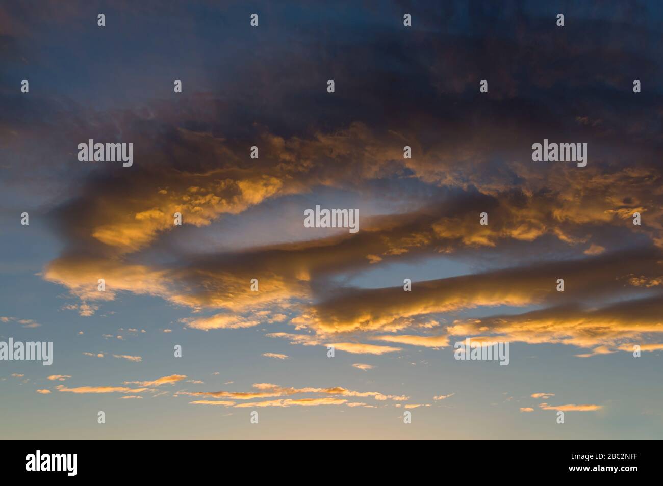 Cielo drammatico nube con nuvole di pioggia scura e nuvole luminose illuminate dal sole basso, incandescente nella sera bagliore prima e dopo una tempesta in Foto Stock