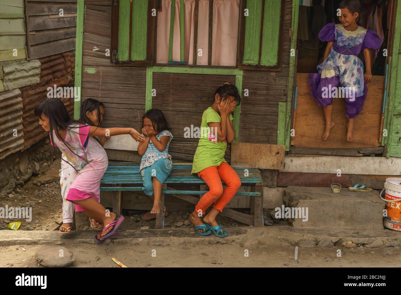 21 giugno 2018 Panyambungan, Sumatra, Indonesia: Ragazze locali timide ed eccitate di una macchina fotografica che si allontana coprendo i volti e ridendo Foto Stock