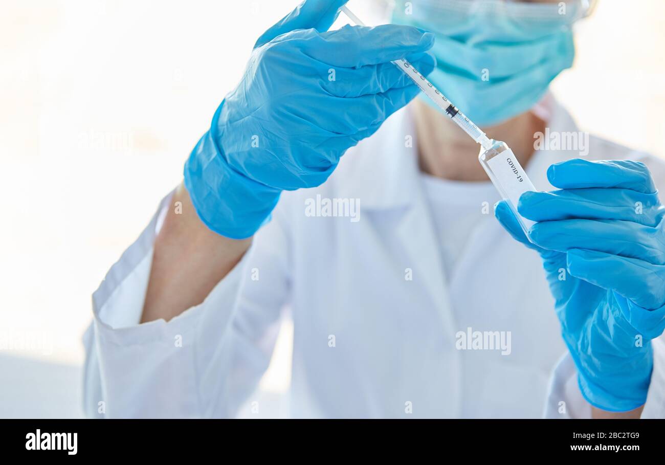 Ricercatori che utilizzano il vaccino da anticorpi contro Covid-19 in laboratorio durante una pandemia di coronavirus Foto Stock