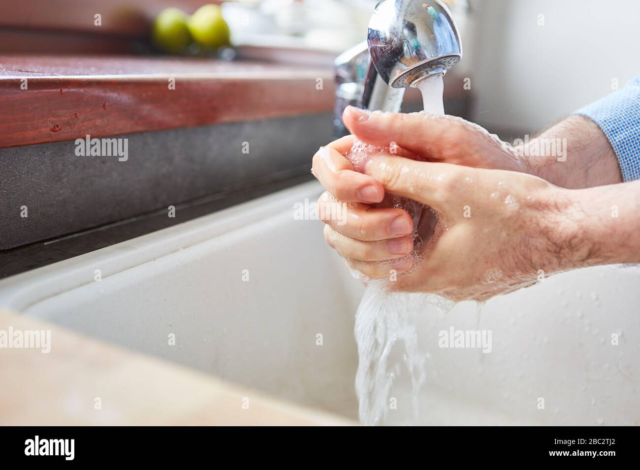 Lavarsi le mani con acqua e sapone contro il coronavirus nella pandemia di Covid-19 Foto Stock