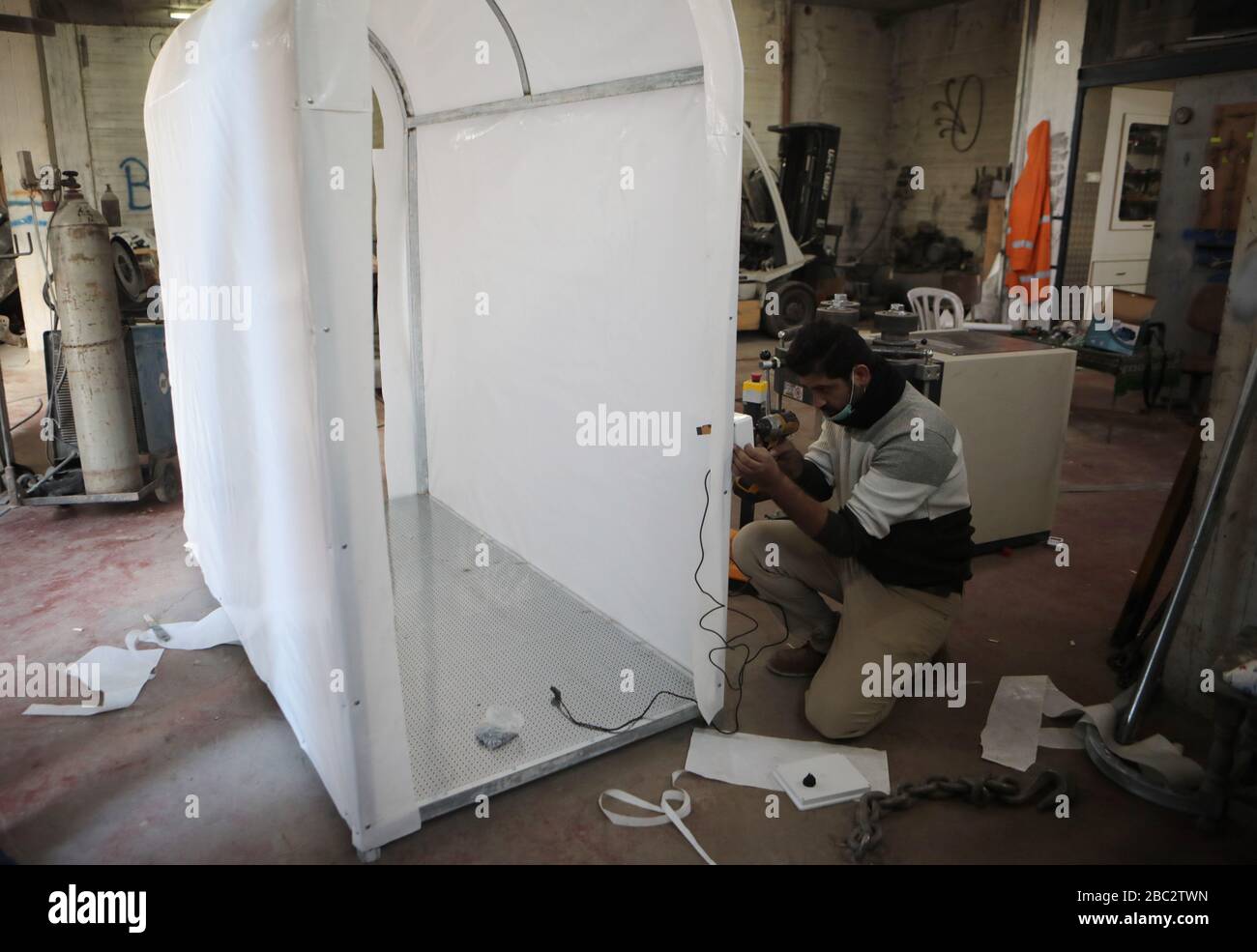 Hebron, città della Cisgiordania di Hebron. 2nd Apr, 2020. L'ingegnere palestinese Tariq al-Najjar lavora per realizzare una camera di sterilizzazione mobile che spruzza disinfettante, presso il suo laboratorio nella città di Hebron, nella Cisgiordania, il 2 aprile 2020. La Palestina giovedì ha dichiarato cinque nuovi casi COVID-19, portando il numero totale di casi confermati nei territori palestinesi a 160. Credit: Mamoun Wazwaz/Xinhua/Alamy Live News Foto Stock