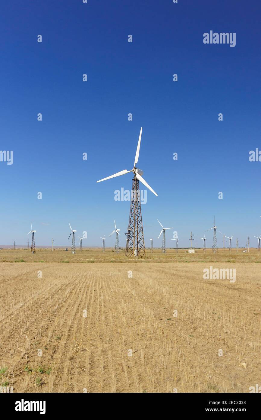 Una turbina eolica che gira contro un cielo blu chiaro. Energia alternativa della Crimea. Parco eolico Foto Stock