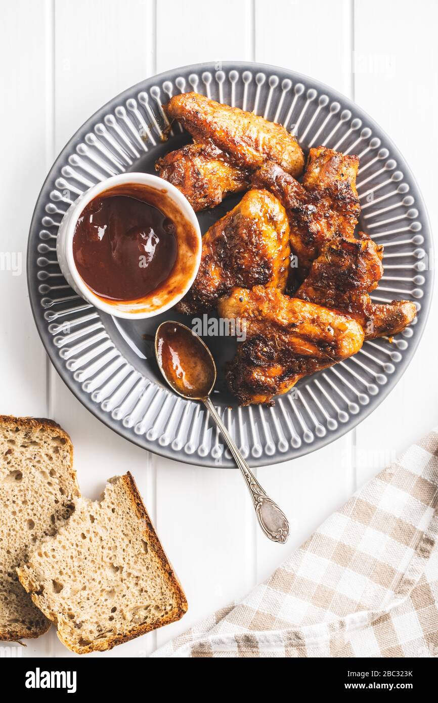 Ali di pollo alla griglia su piastra con salsa barbecue. Vista dall'alto. Foto Stock