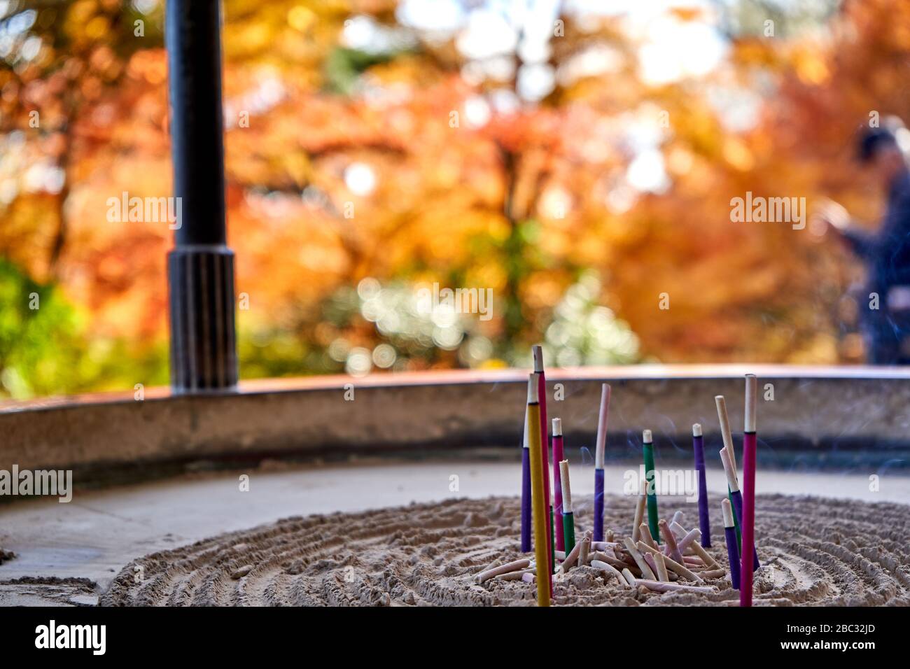 Fumo che esce dall'incenso vicino al tempio in autunno Foto Stock