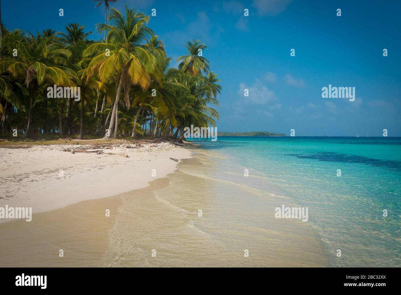 Una spiaggia di sabbia bianca vuota con palme e acqua cristallina acquamarina. Foto Stock