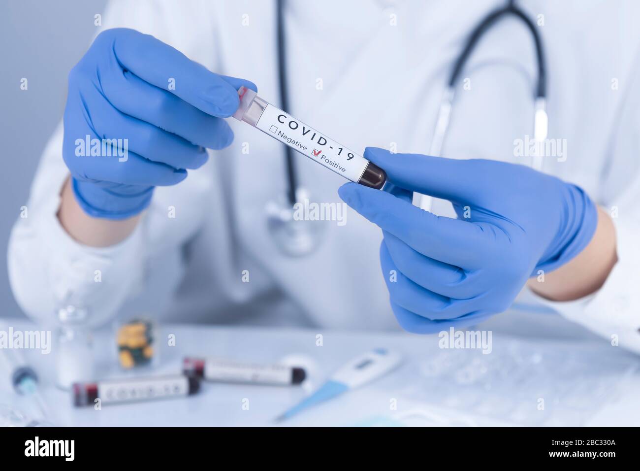 Le mani del medico con i guanti protettivi che analizzano il sangue di prova di Coronavirus COVID 19. Test antivirus e concetto di ricerca. Primo piano Foto Stock