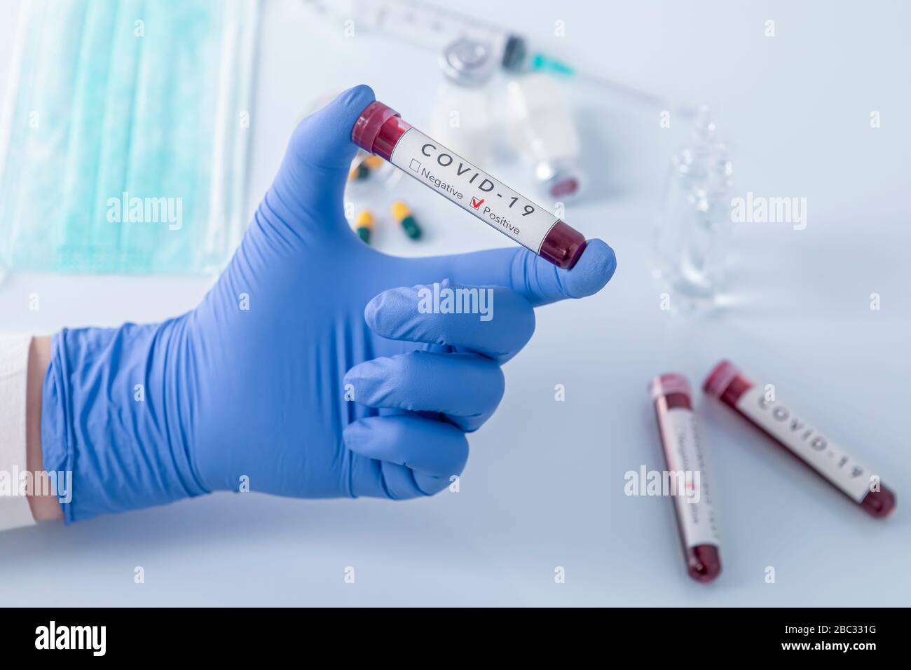 Mano del medico con guanti protettivi che tengono il sangue di prova di Coronavirus COVID 19. Test antivirus e concetto di ricerca. Concentrarsi sul sangue di prova in mano. Foto Stock Mano del medico con guanti protettivi che tengono il sangue di prova di Coronavirus COVID 19. Test antivirus e concetto di ricerca. Concentrarsi sul sangue di prova in mano. Foto Stock