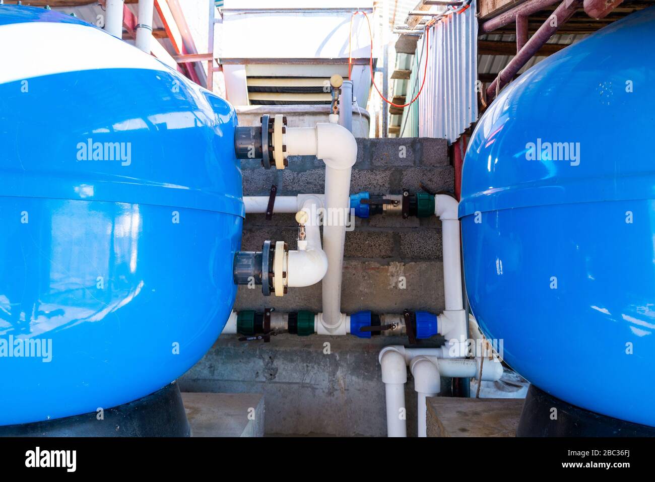 Sistema che pompa acqua per agricoltura. Grandi serbatoi di prolunga blu con sistema di acqua tubi in PVC. Foto Stock