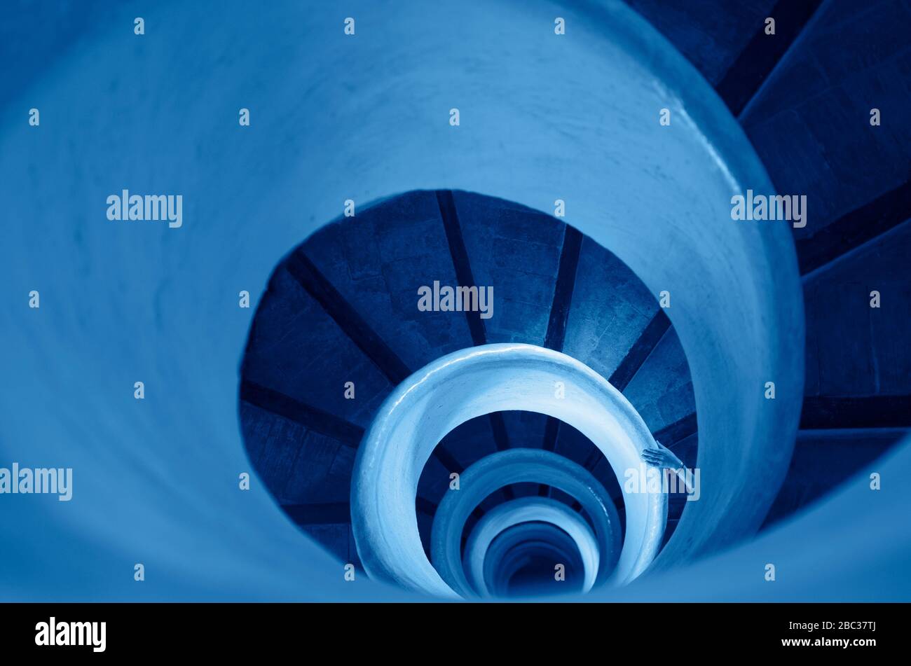 Vecchie scale in scala a chiocciola con tonalità a mano in blu classico - colore dell'anno 2020 Foto Stock