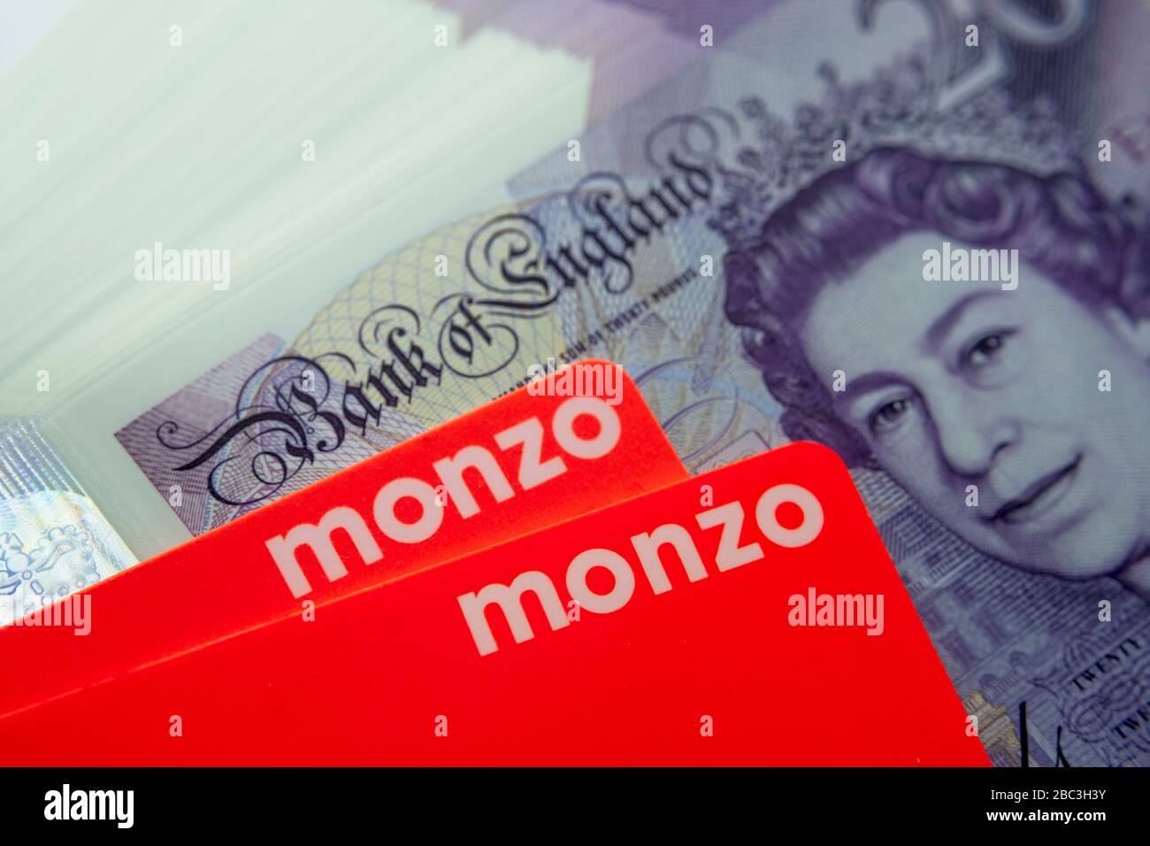 Carta bancaria Monzo collocata sopra le note di nuovo polimero 20 libbre. Chiudi la foto. Foto Stock