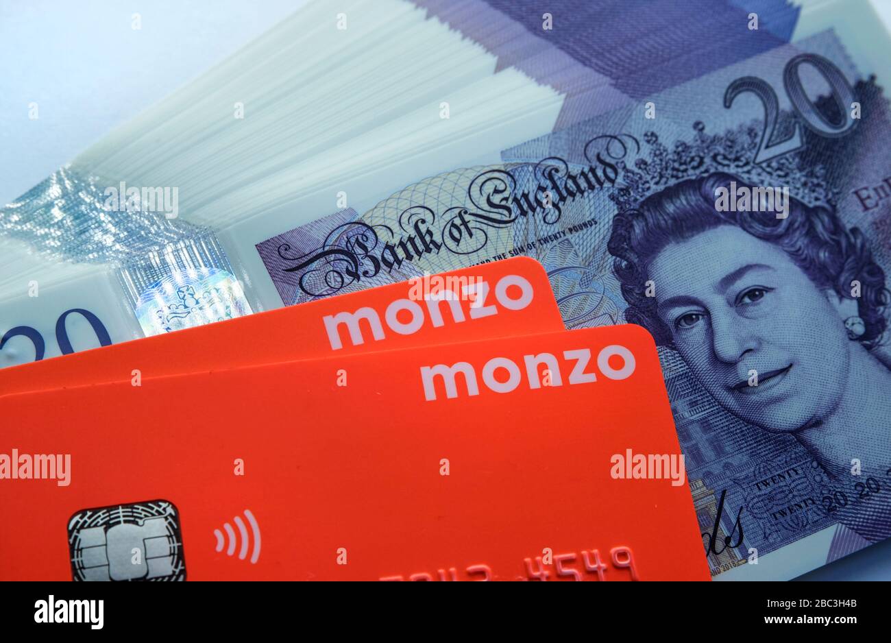 Carta bancaria Monzo collocata sopra le note di nuovo polimero 20 libbre. Chiudi la foto. Foto Stock