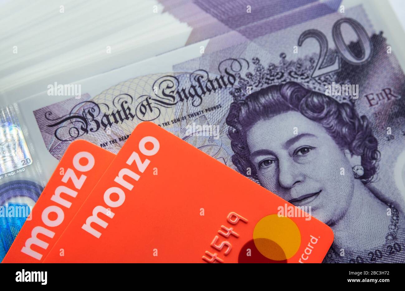 Carta bancaria Monzo collocata sopra le note di nuovo polimero 20 libbre. Chiudi la foto. Foto Stock