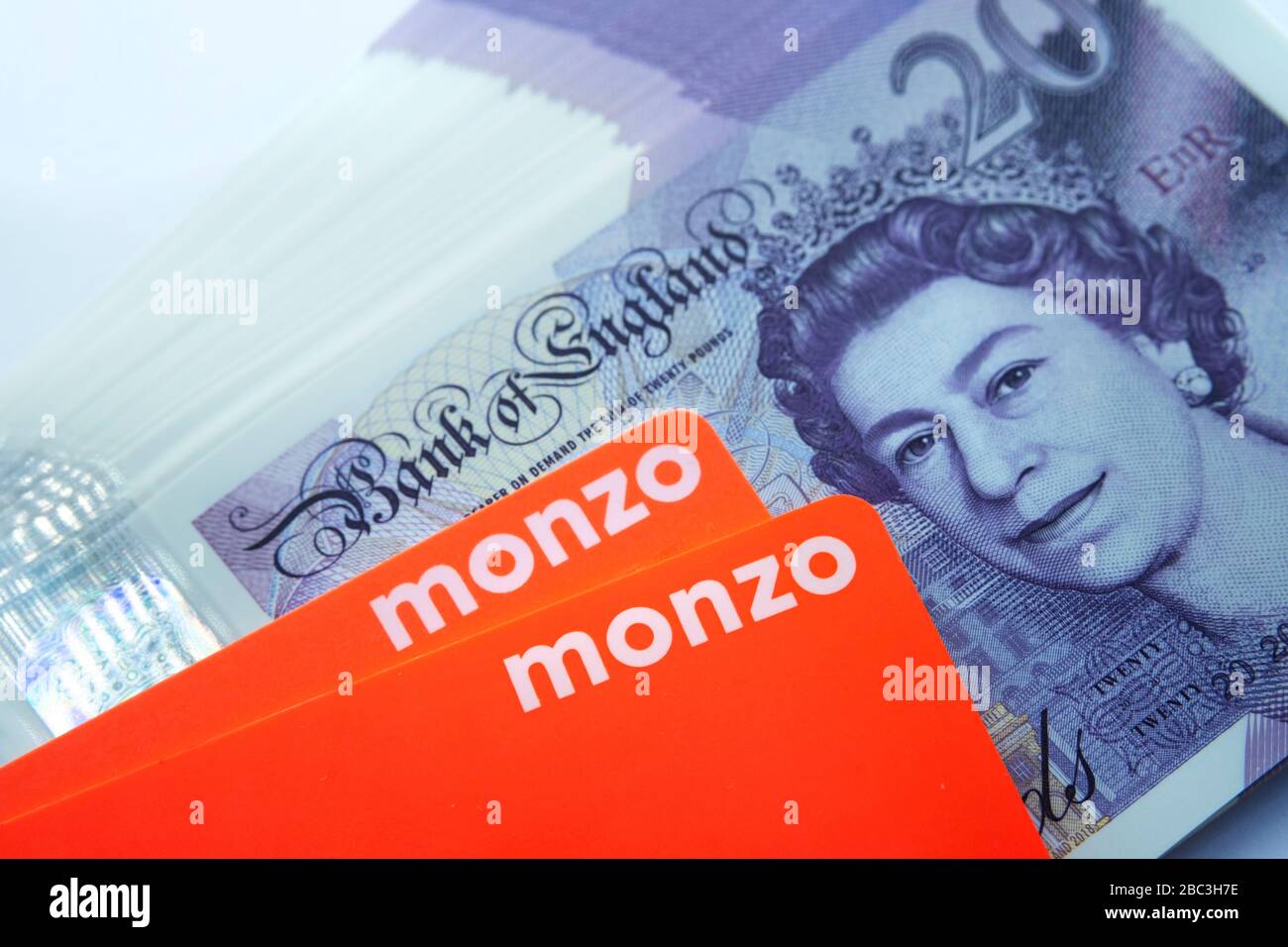 Carta bancaria Monzo collocata sopra le note di nuovo polimero 20 libbre. Chiudi la foto. Foto Stock