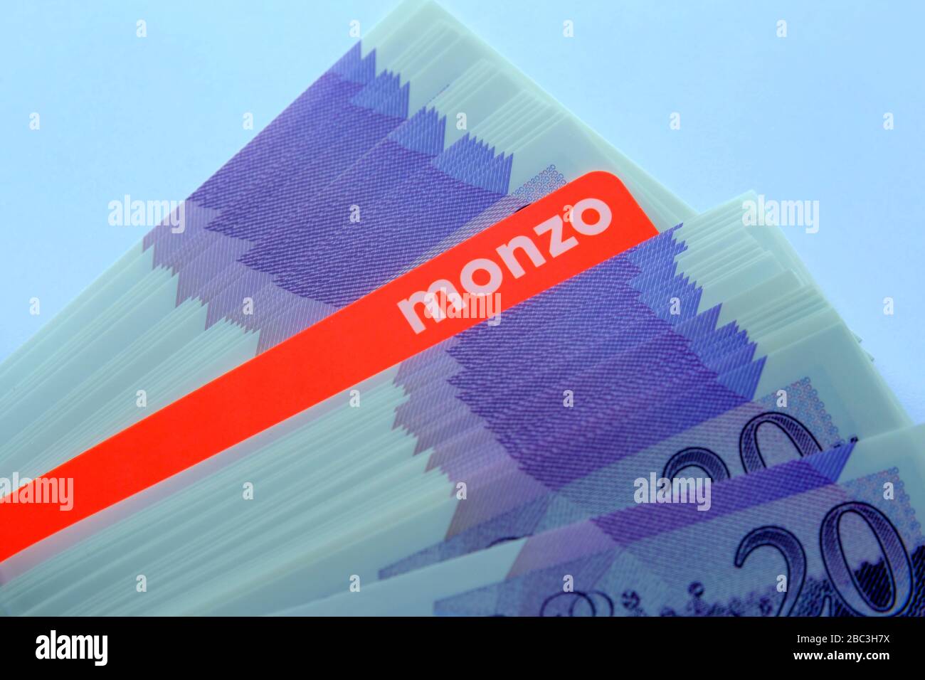 Carta bancaria Monzo collocata sopra le note di nuovo polimero 20 libbre. Chiudi la foto. Foto Stock