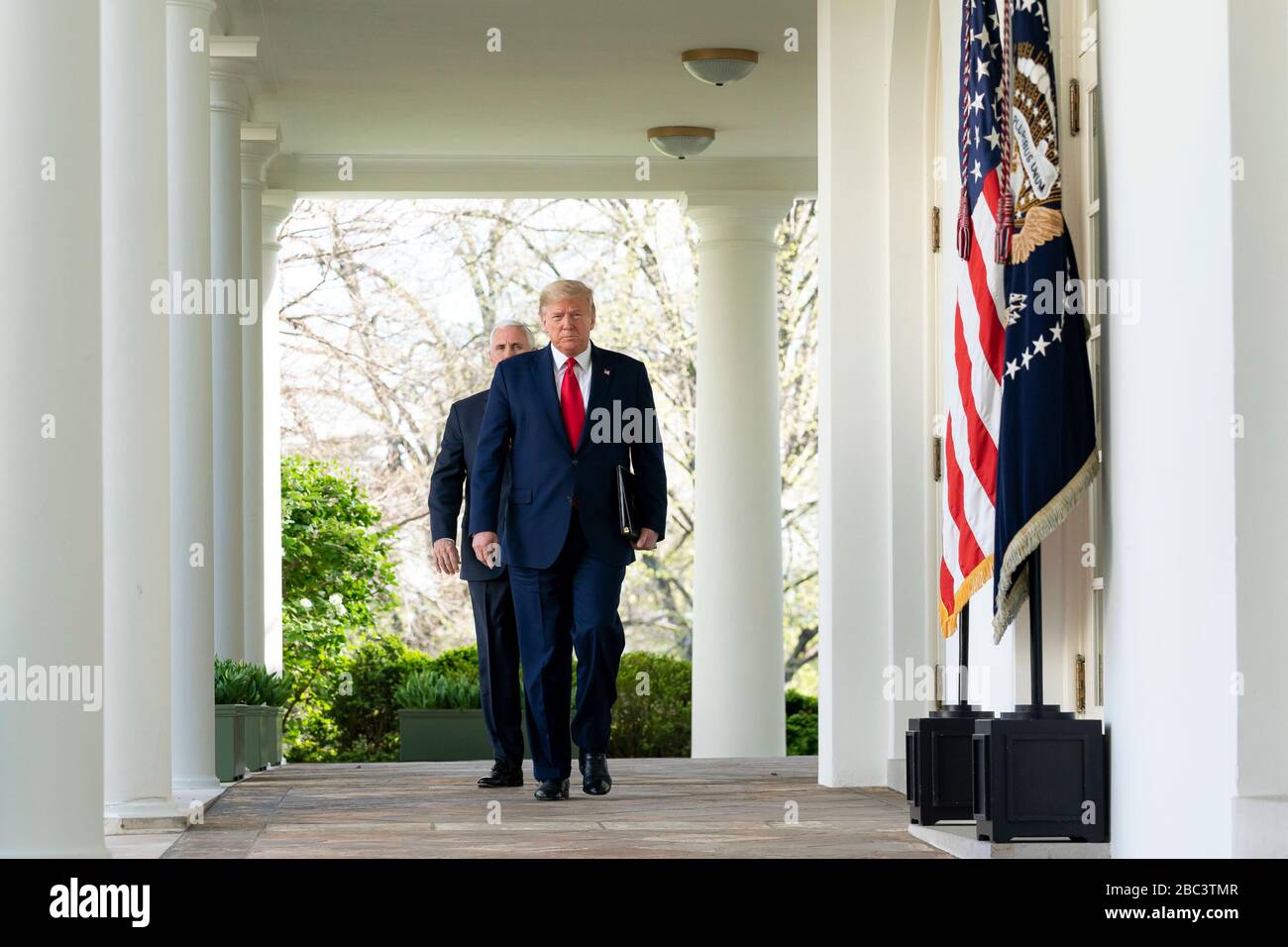 Il presidente degli Stati Uniti Donald Trump e il vicepresidente Mike Pence camminano lungo la West Colonnade verso il Rose Garden per il quotidiano COVID-19, briefing sul coronavirus il 30 marzo 2020 a Washington, DC. Foto Stock