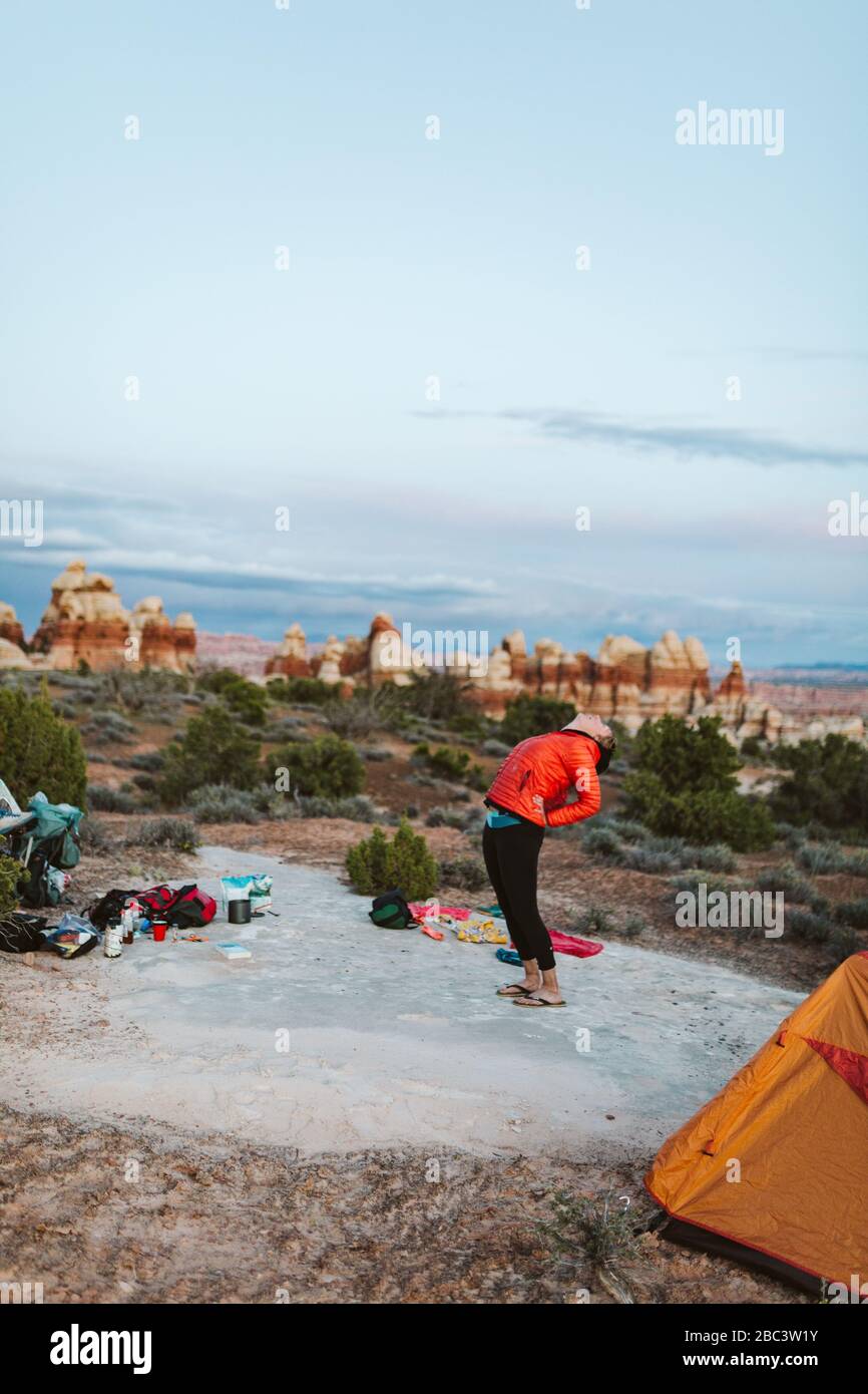 la schiena femminile di camper si piega prima di andare a dormire nel deserto dello utah Foto Stock