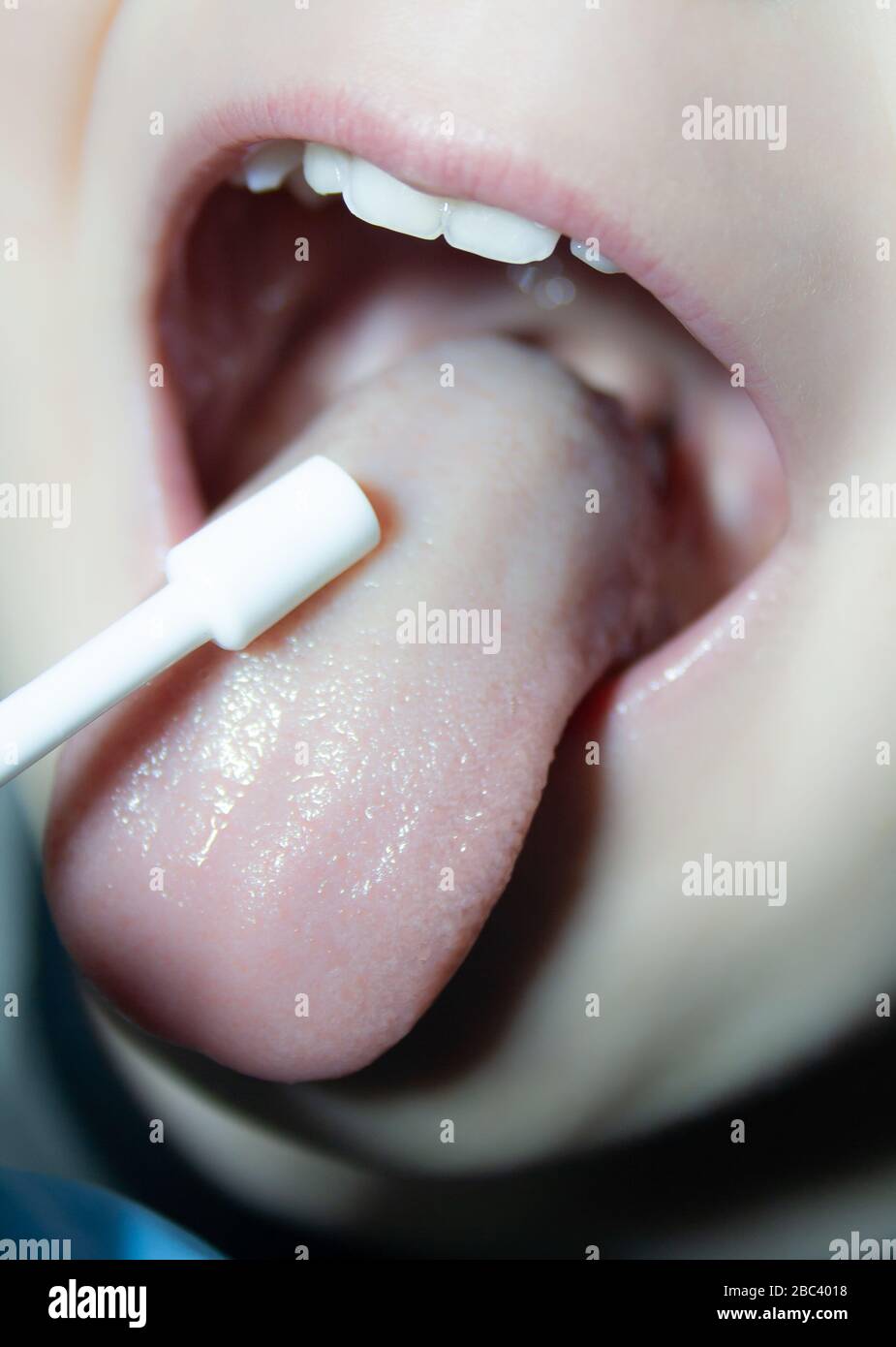 il medico spruzza la gola per un bambino malato Foto Stock