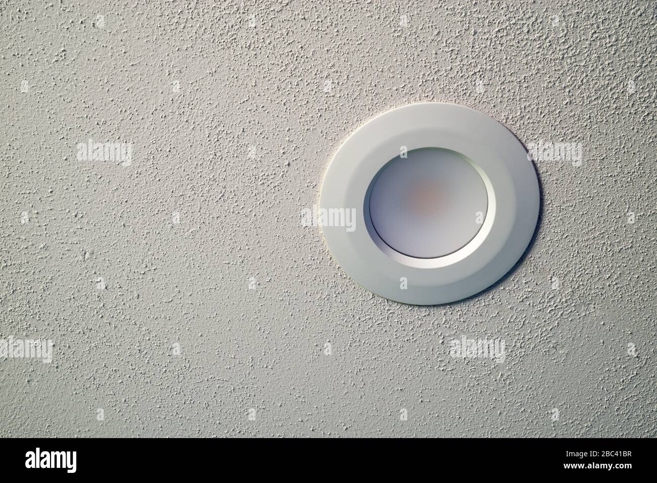 Plafoniera a LED su soffitto bianco a spackle testurizzato Foto Stock