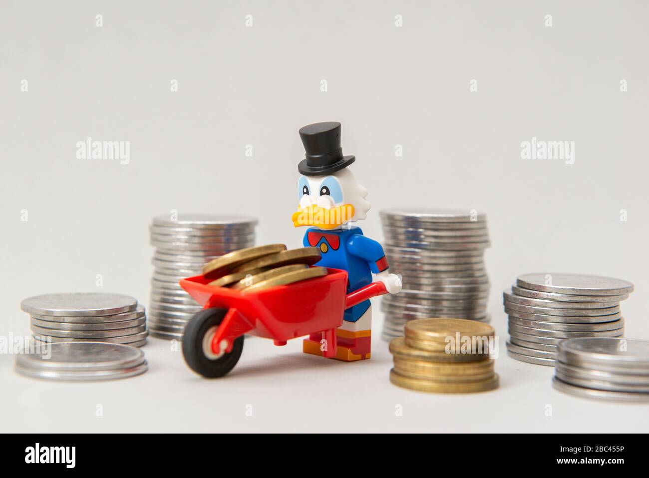 Florianopolis, Brasile, 28 marzo 2020: LEGO Minifigure di Scrooge McDuck con monete da portare su una carriola su sfondo bianco. Messa a fuoco selettiva. LEGO mi Foto Stock
