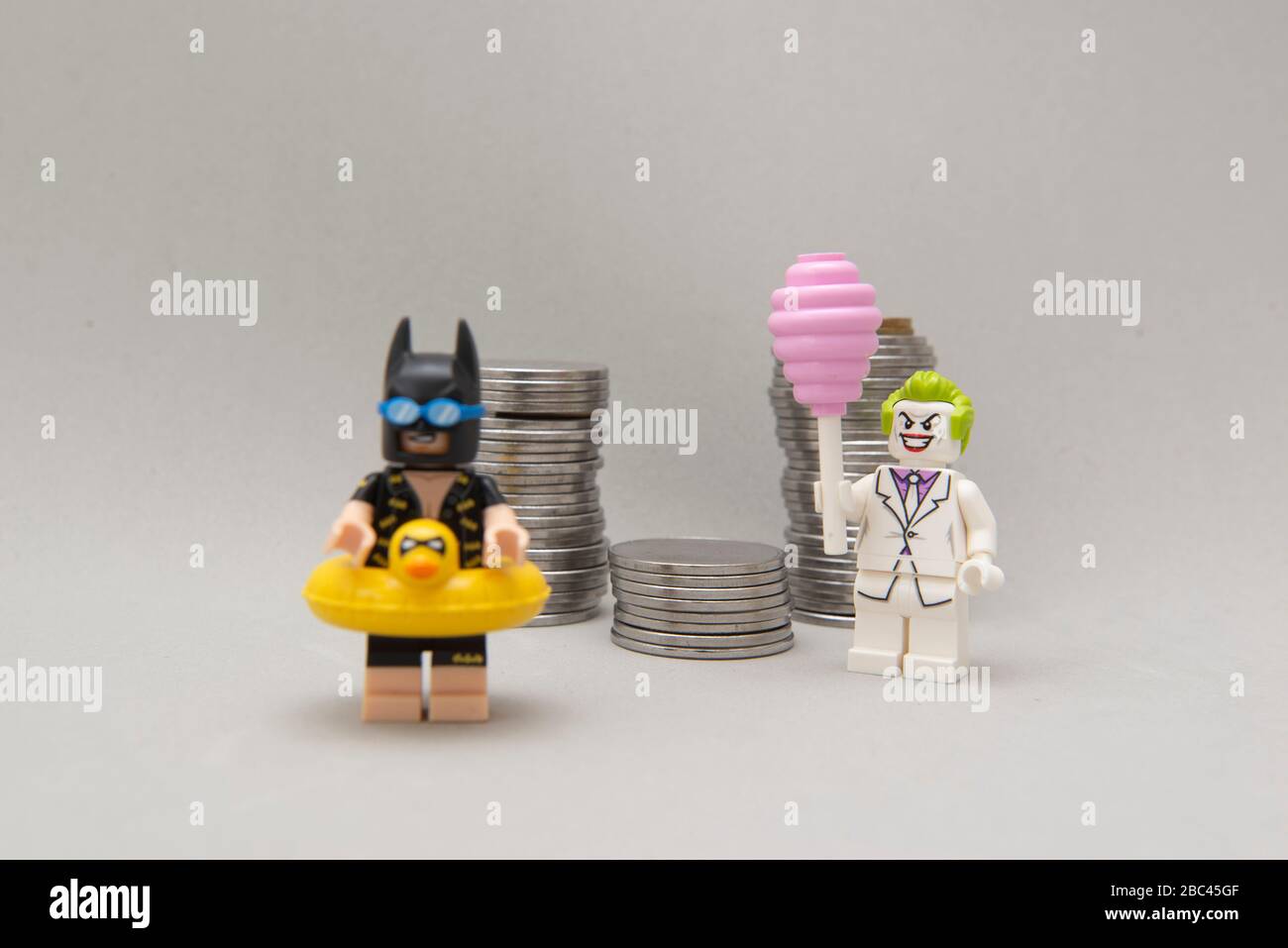 Florianopolis, Brasile, 28 marzo 2020: Minisfigure di Batman con costume da bagno e vacanza e burlone che ruba denaro. Il supereroe non può riposare. Il crimine non SL Foto Stock