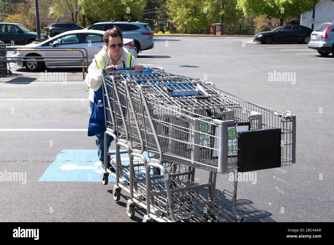 Canton, Georgia, Stati Uniti. 2nd Apr, 2020. Chris Nelson, 36, che ha una disabilità evolutiva, raccoglie carrelli di shopping al di fuori di un supermercato Kroger dove heÃs ha lavorato part-time per più di un anno. È considerato un Ã"essenziale workerÃ perché è impiegato da un negozio di alimentari, ed è attento a pulire i carrelli con disinfettanti quando li restituisce al negozio. Credit: Robin Rayne/ZUMA Wire/Alamy Live News Foto Stock