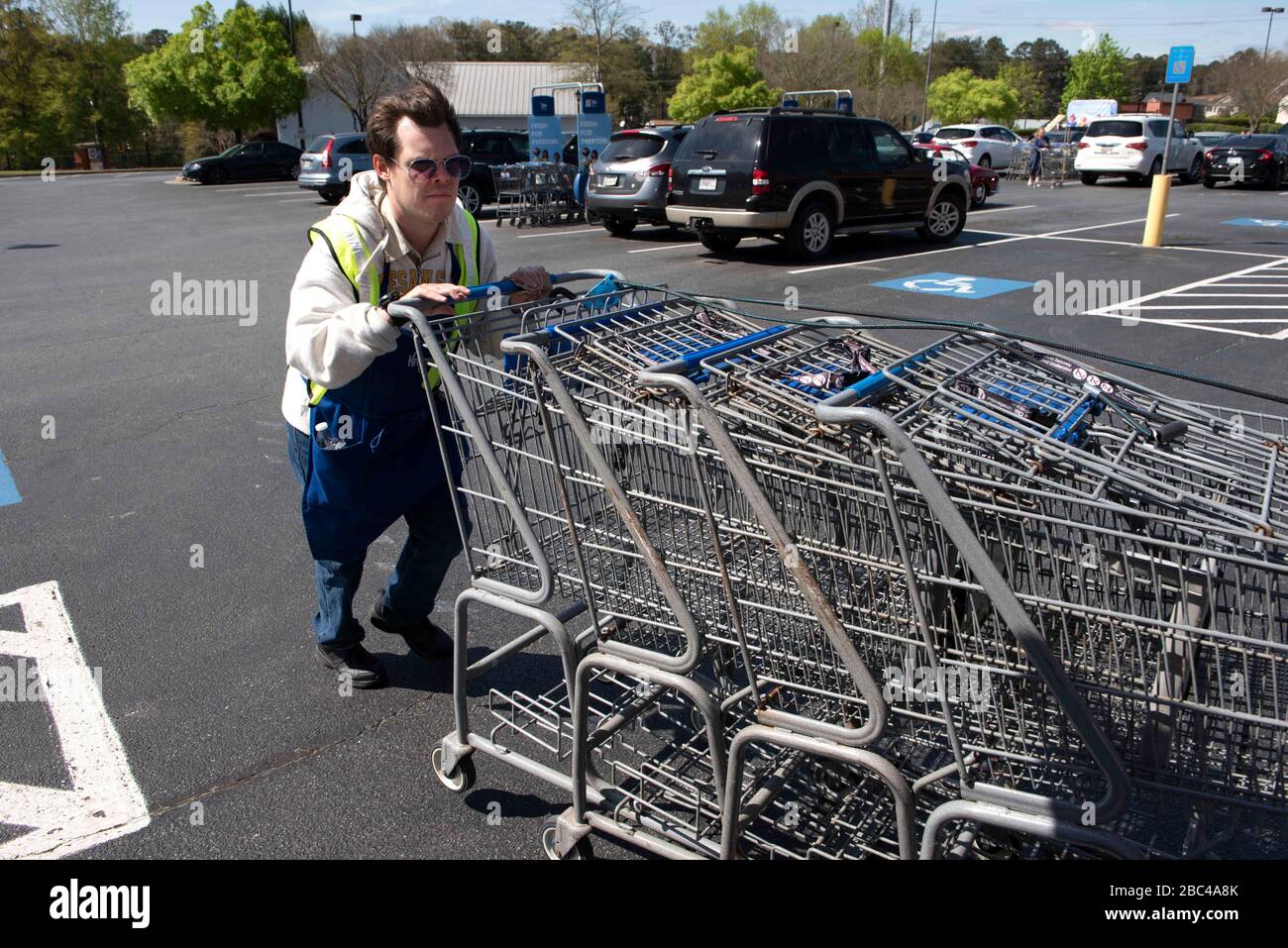 Canton, Georgia, Stati Uniti. 2nd Apr, 2020. Chris Nelson, 36, che ha una disabilità evolutiva, raccoglie carrelli di shopping al di fuori di un supermercato Kroger dove heÃs ha lavorato part-time per più di un anno. È considerato un Ã"essenziale workerÃ perché è impiegato da un negozio di alimentari, ed è attento a pulire i carrelli con disinfettanti quando li restituisce al negozio. Credit: Robin Rayne/ZUMA Wire/Alamy Live News Foto Stock