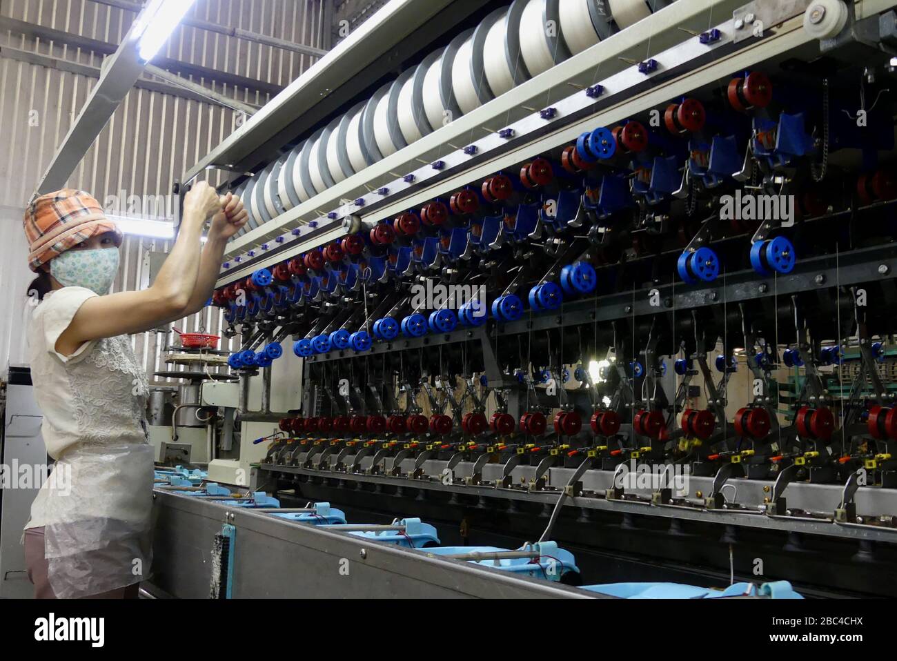Donna che lavora su una macchina in una fabbrica di seta a da Lat, Vietnam Foto Stock
