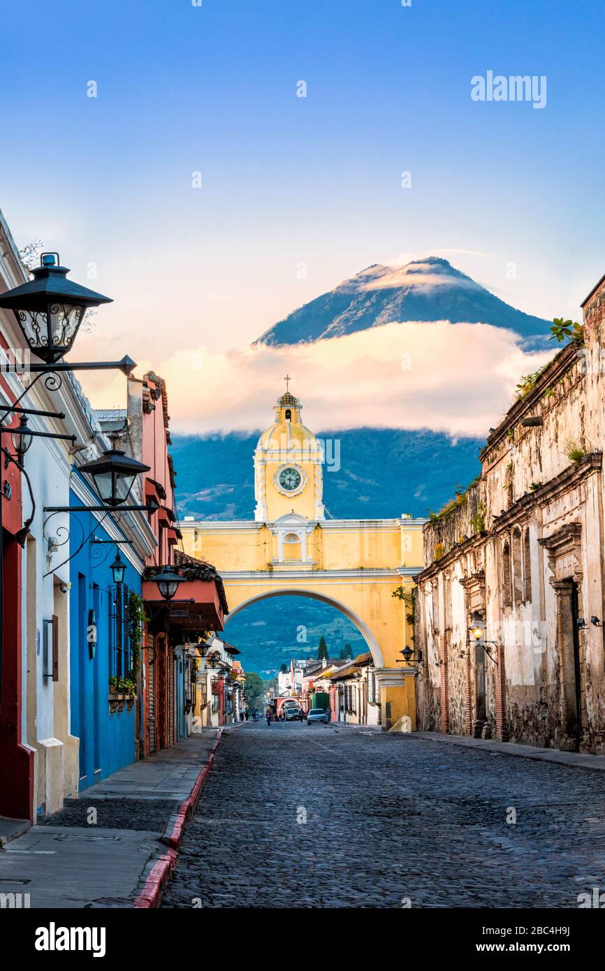 L'iconico arco di Santa Catalina ad Antigua, Guatemala, con il vulcano Agua sullo sfondo. Foto Stock