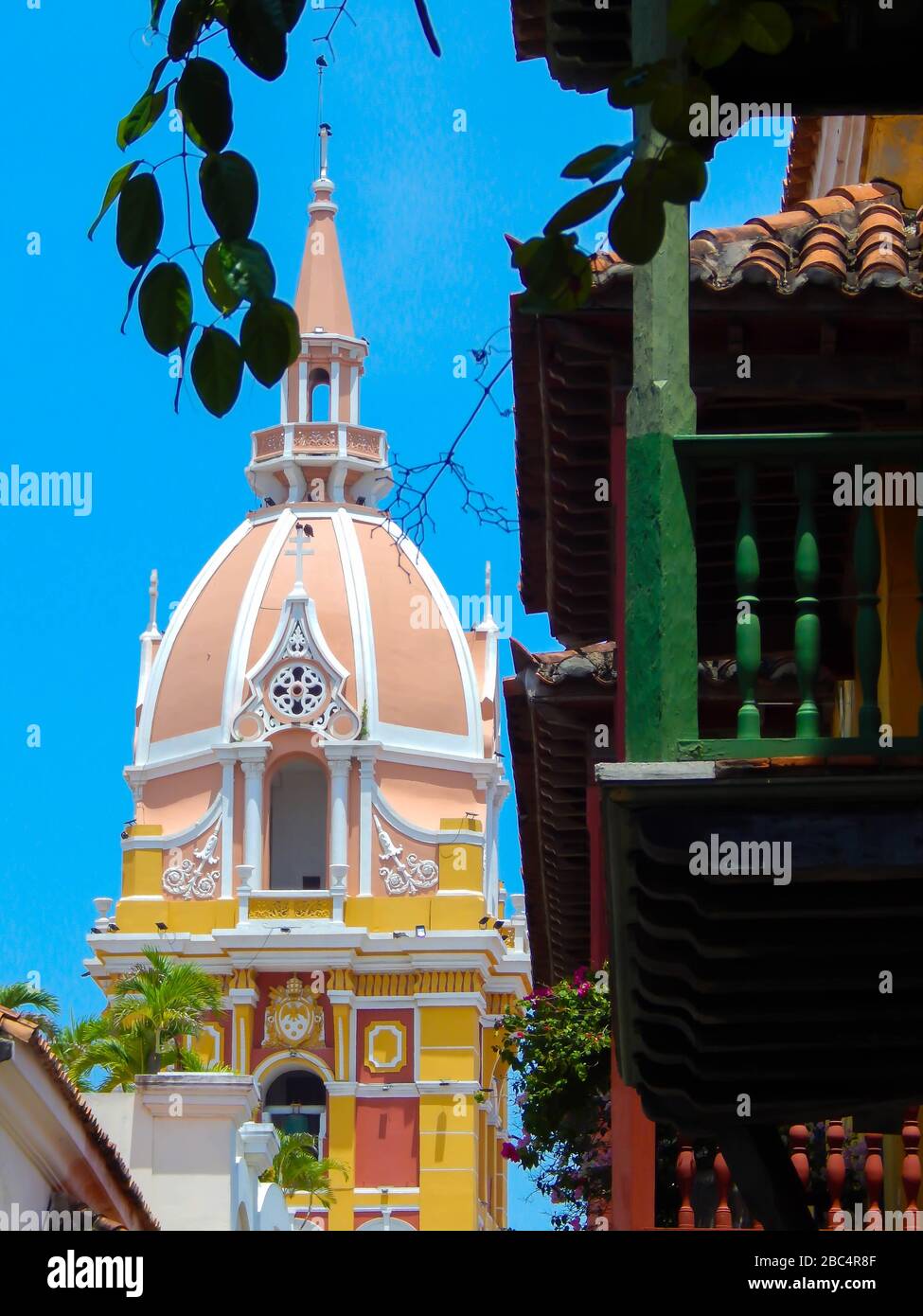 vista della cattedrale e delle piante sospese sui balconi da una strada a cartagena colombia Foto Stock