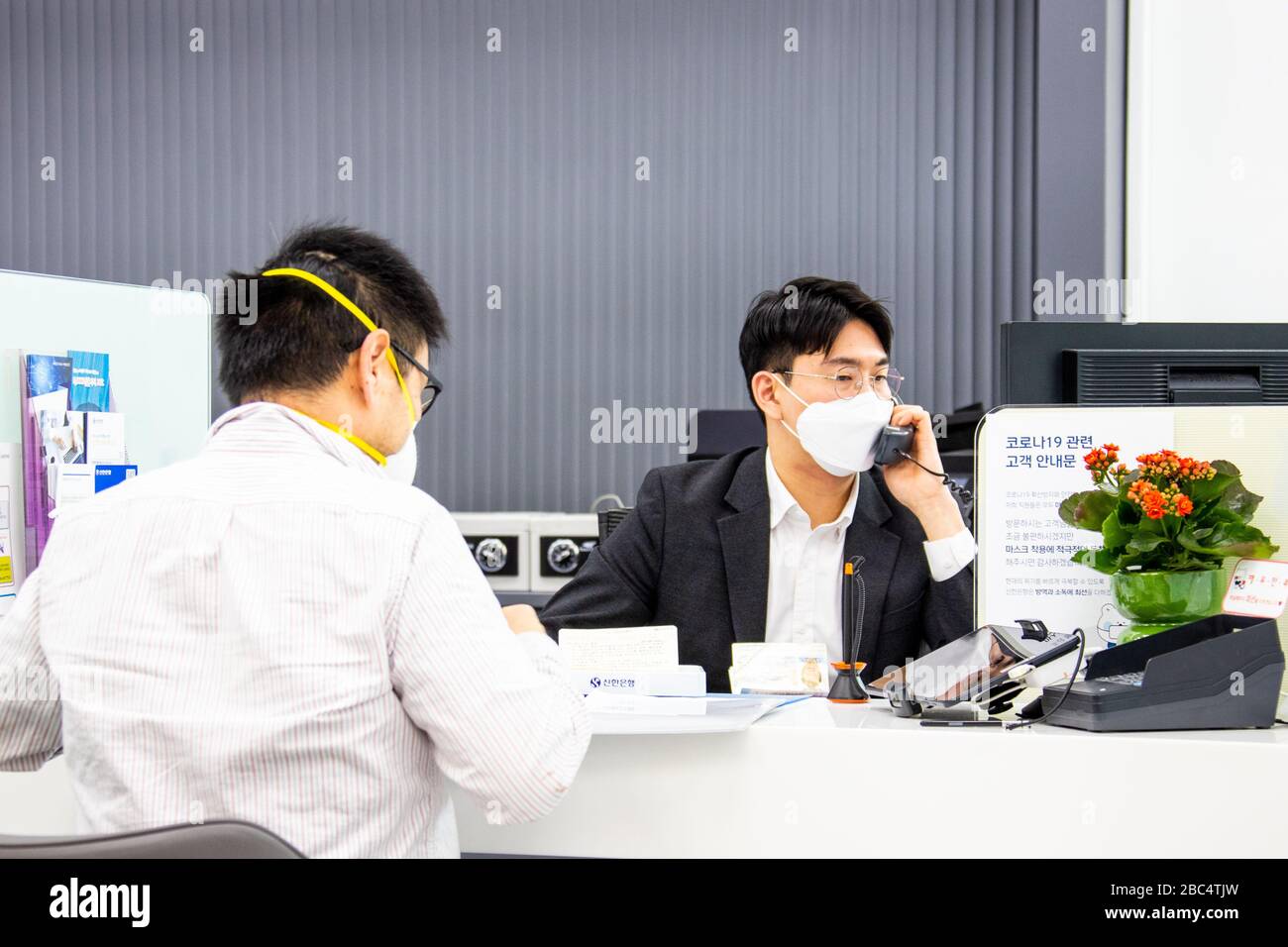 Banche a Shinhan mentre indossava una maschera durante la pandemia di Coronavirus, Seoul, Corea del Sud Foto Stock