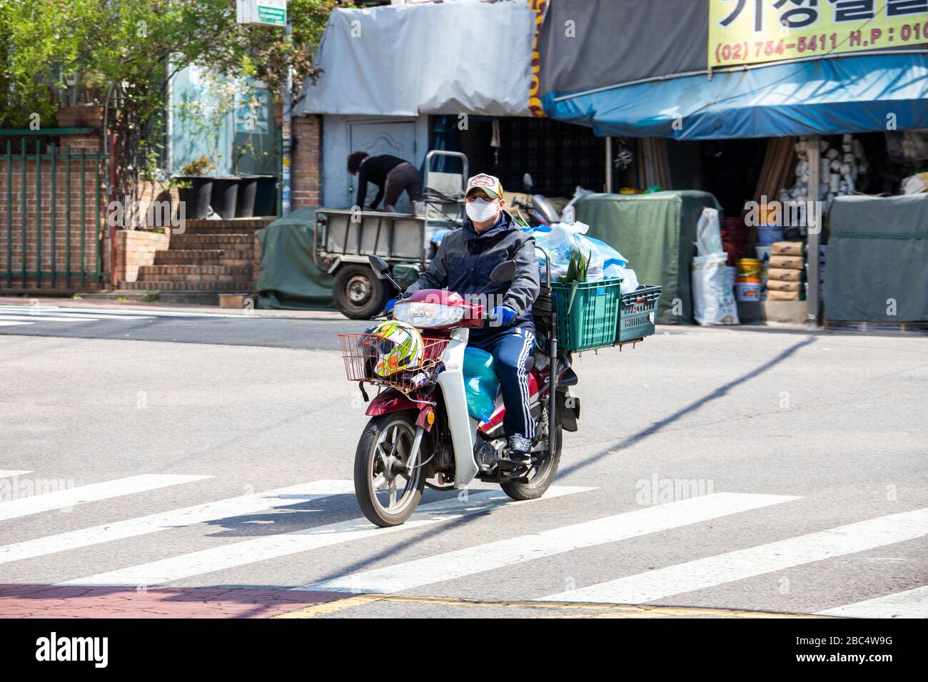 Consegna moto indossando una maschera durante la pandemia di Coronavirus, Seoul, Corea del Sud Foto Stock