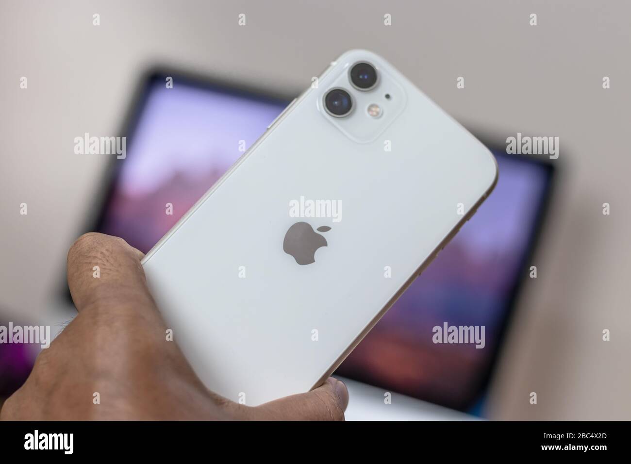 Sul retro dell'iPhone 11, variante bianca, tenendolo a portata di mano Foto Stock