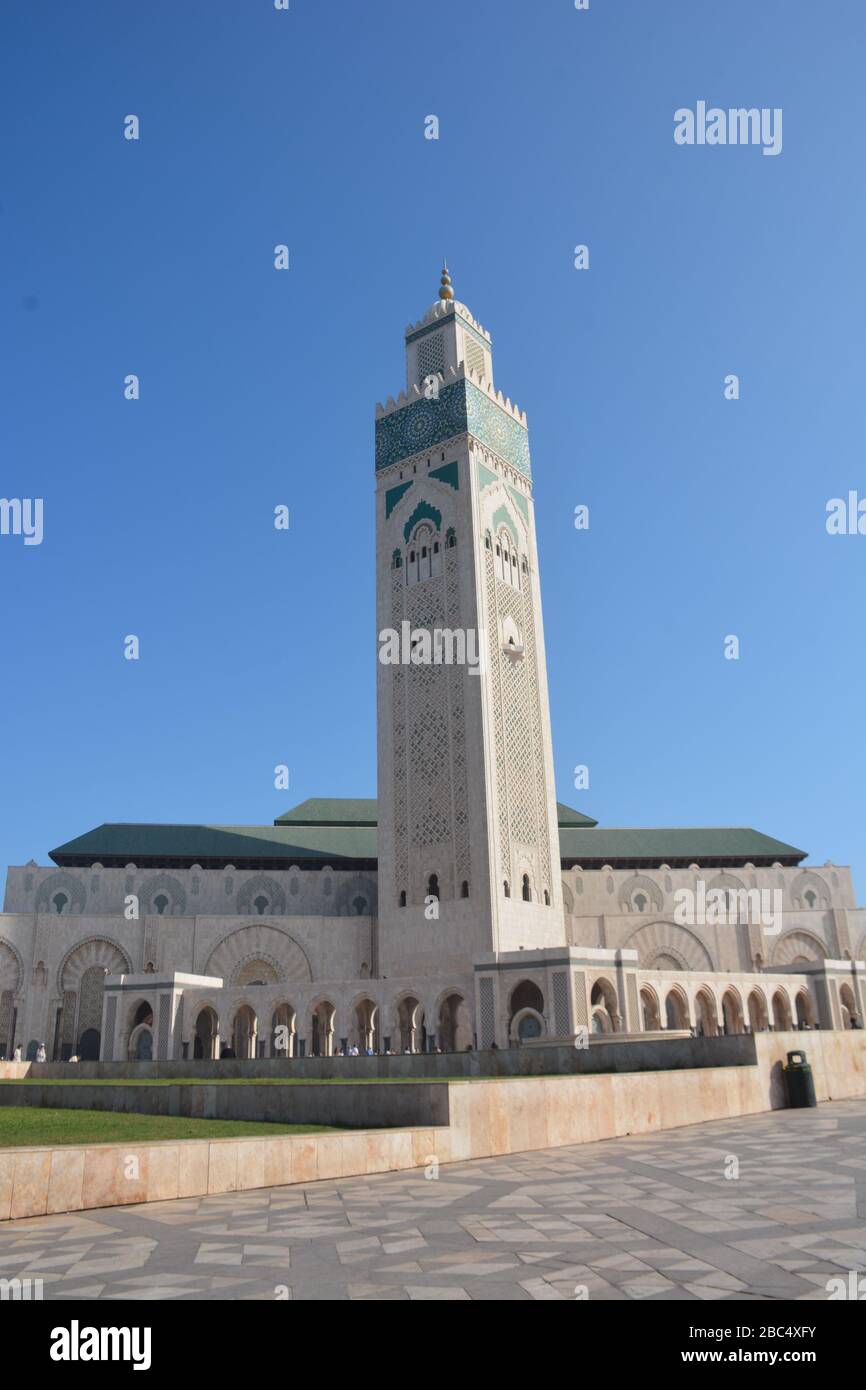 Drammatica immagine verticale esterna della Moschea Hassan II, Casablanca, Marocco, che ha il secondo minareto più alto del mondo a 210 metri. Foto Stock