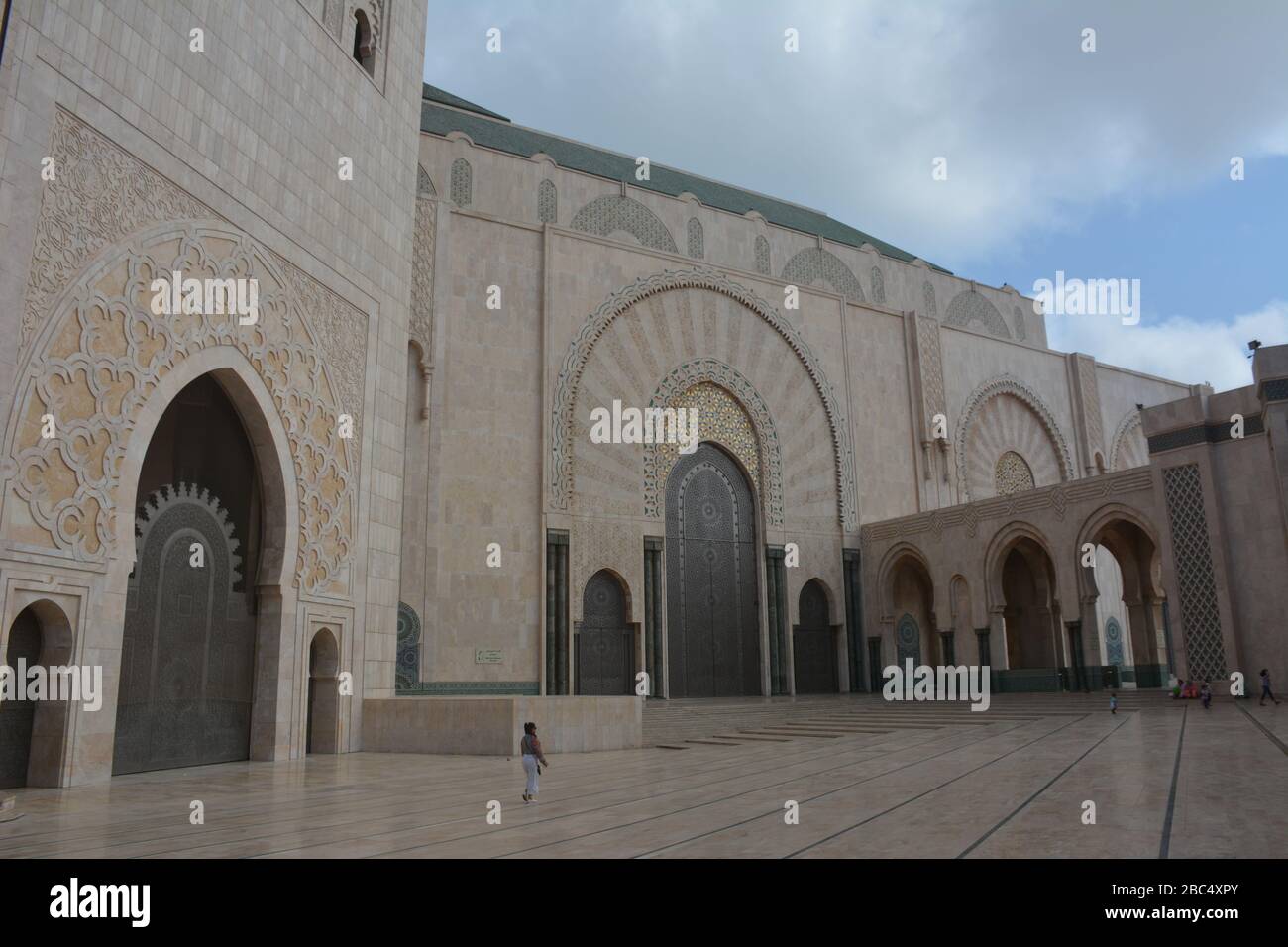 Una figura sola fuori dalla Moschea Hassan II, Casablanca, Marocco, illustra la scala della moschea, la più grande in Africa e la settima al mondo. Foto Stock
