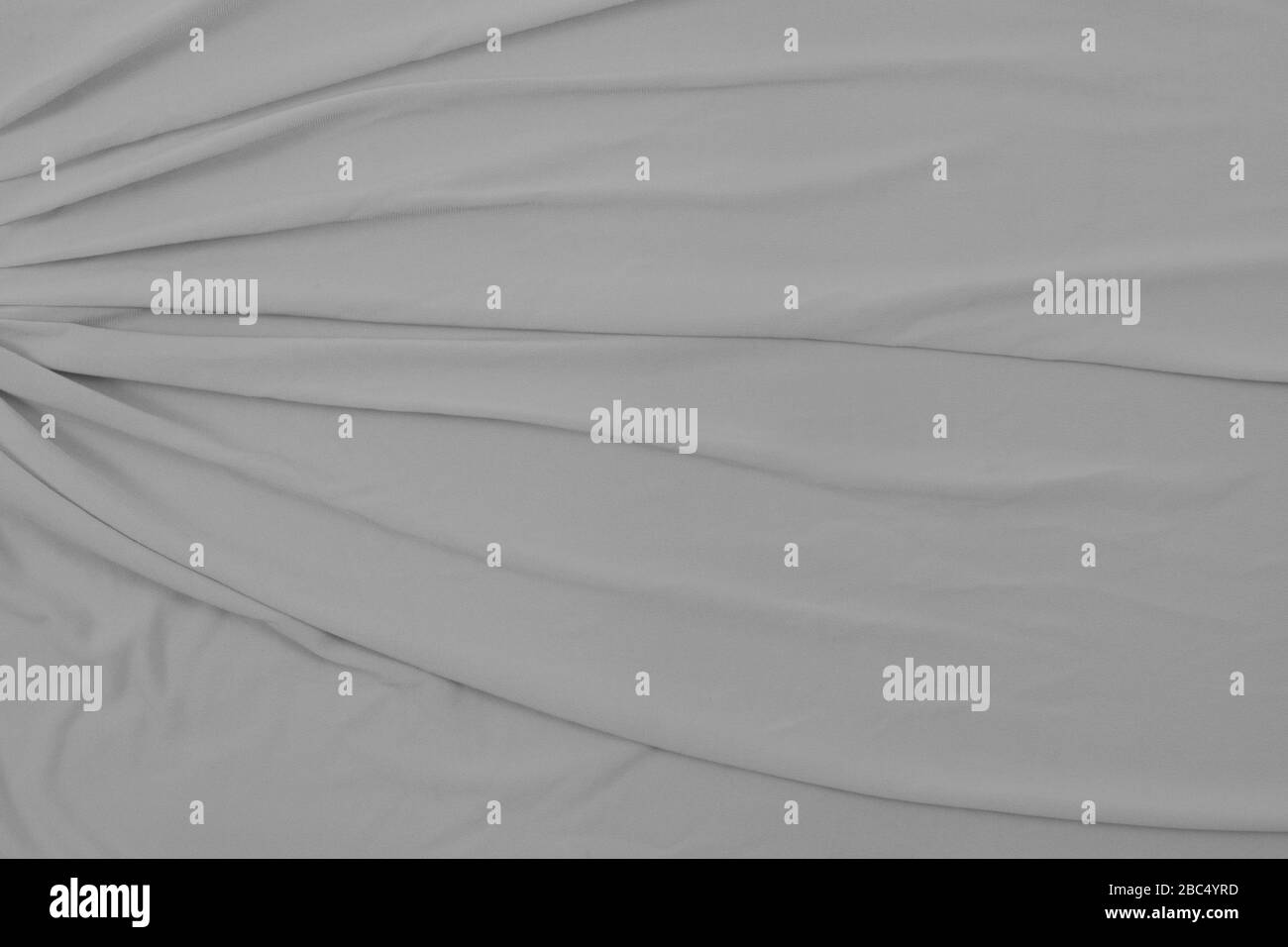 Vista dall'alto verso il basso del tessuto scorrevole grigio chiaro. Ampio spazio per la copia in questa elegante texture di sfondo. Foto Stock