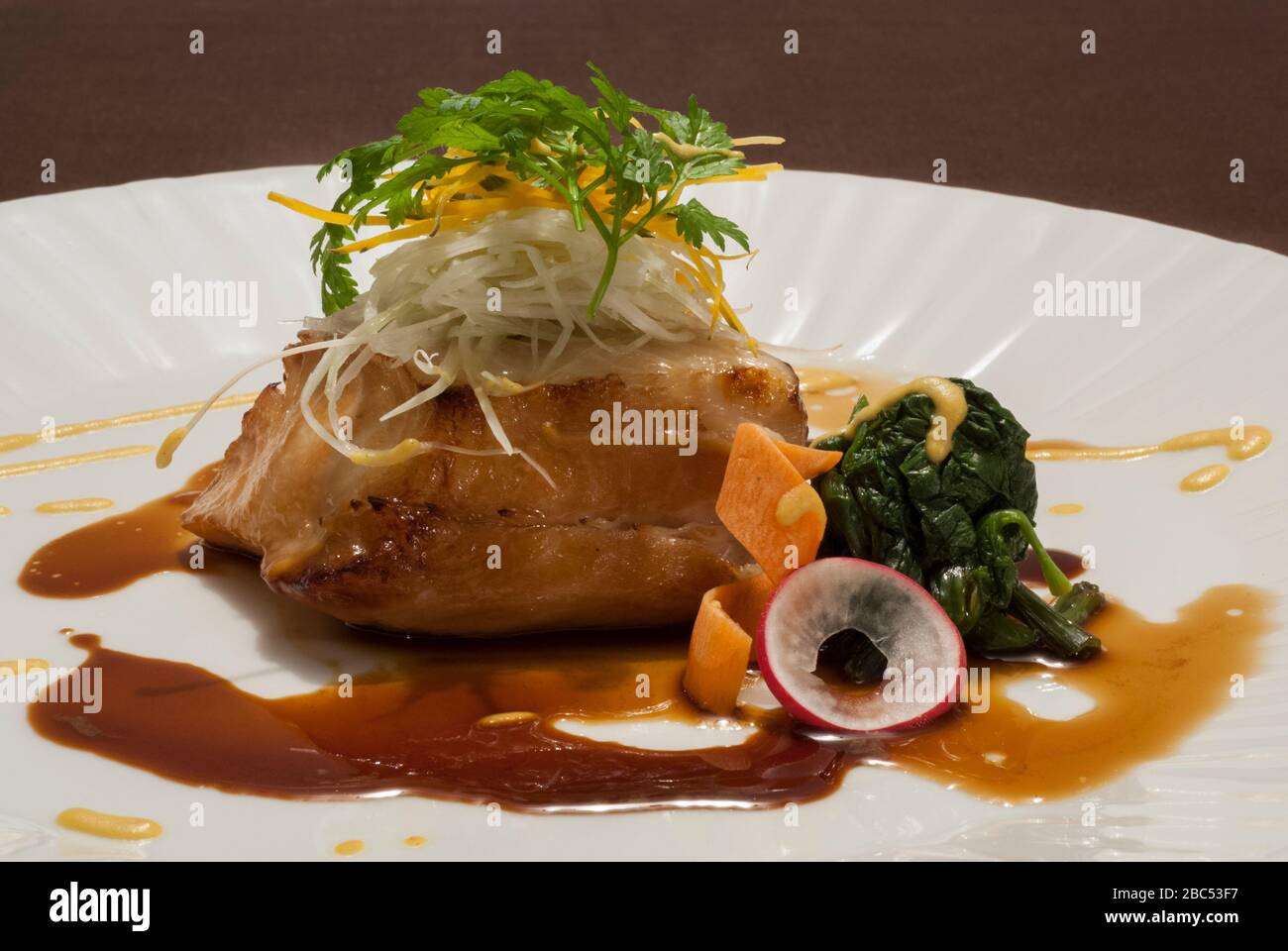 Filetto di pesce alla griglia servito con salsa fusion Foto Stock