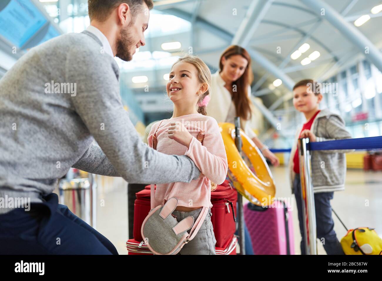 La famiglia con due bambini all'aeroporto viaggia in vacanza con i bagagli Foto Stock