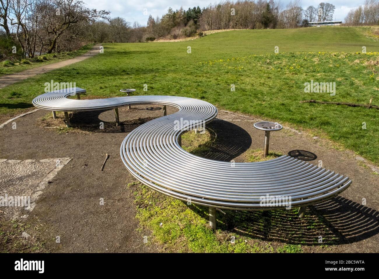 Posti a sedere in un parco in metallo dal design moderno, sul percorso lungo il fiume Almond Park, Livingston, West Lothian. Foto Stock