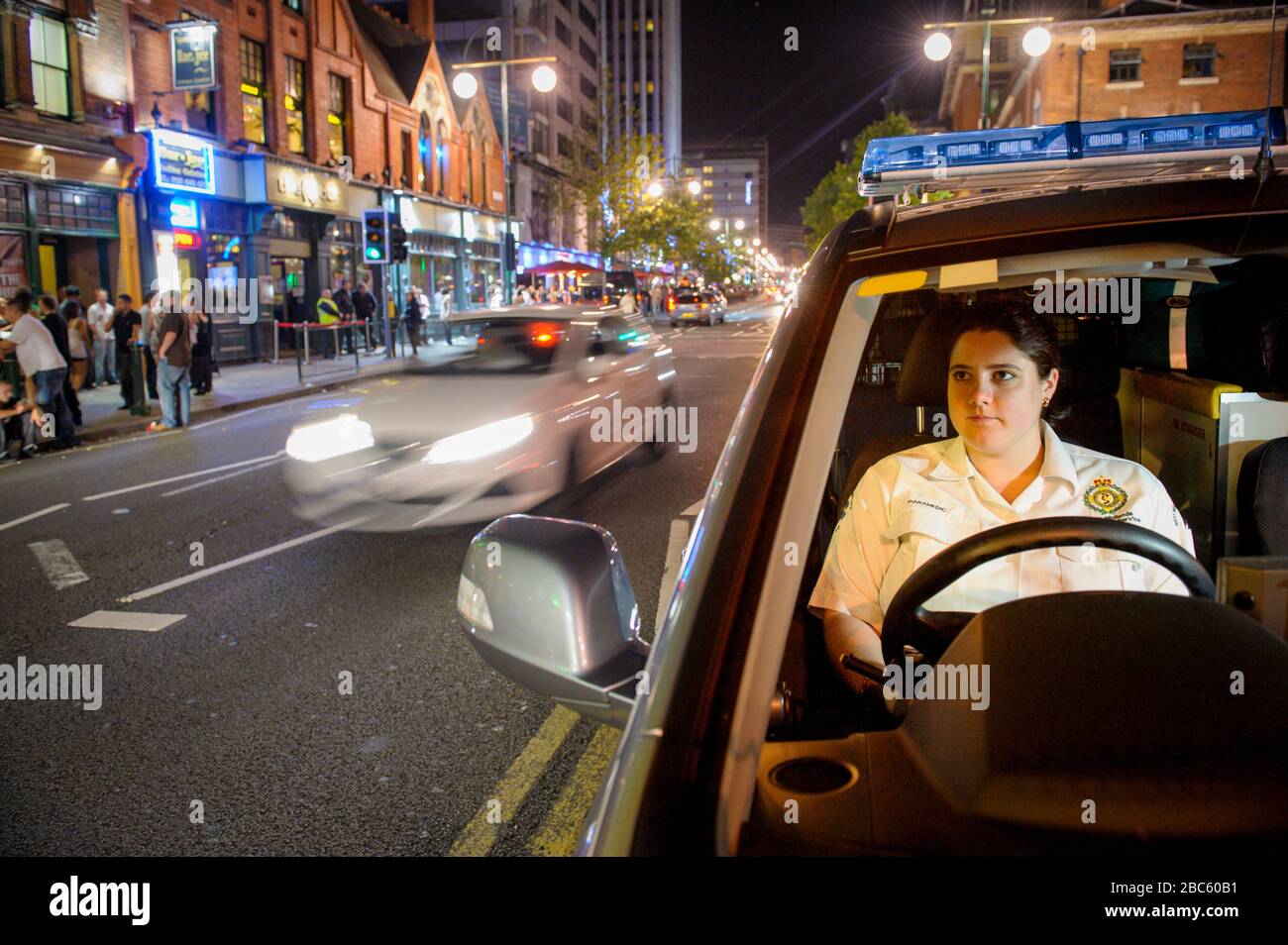 Giovane donna Paramedic in attesa nella sua emergenza veircle Birmingham City Centre su un occupato Sabato notte. Foto Stock