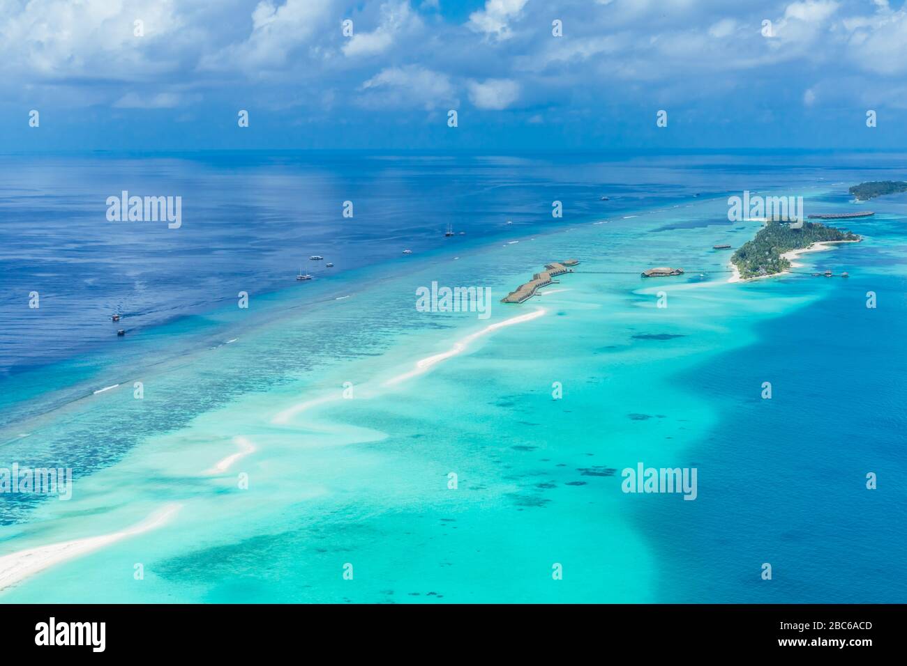 Vista aerea sull'isola delle Maldive. Ville di lusso con acqua e spiaggia, bungalow con un paesaggio meraviglioso natura. Viaggi di lusso e vacanze Foto Stock
