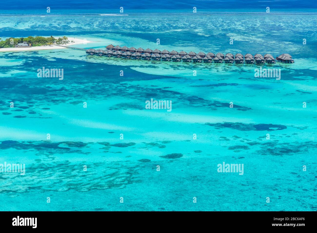 Vista aerea sull'isola delle Maldive. Ville di lusso con acqua e spiaggia, bungalow con un paesaggio meraviglioso natura. Viaggi di lusso e vacanze Foto Stock