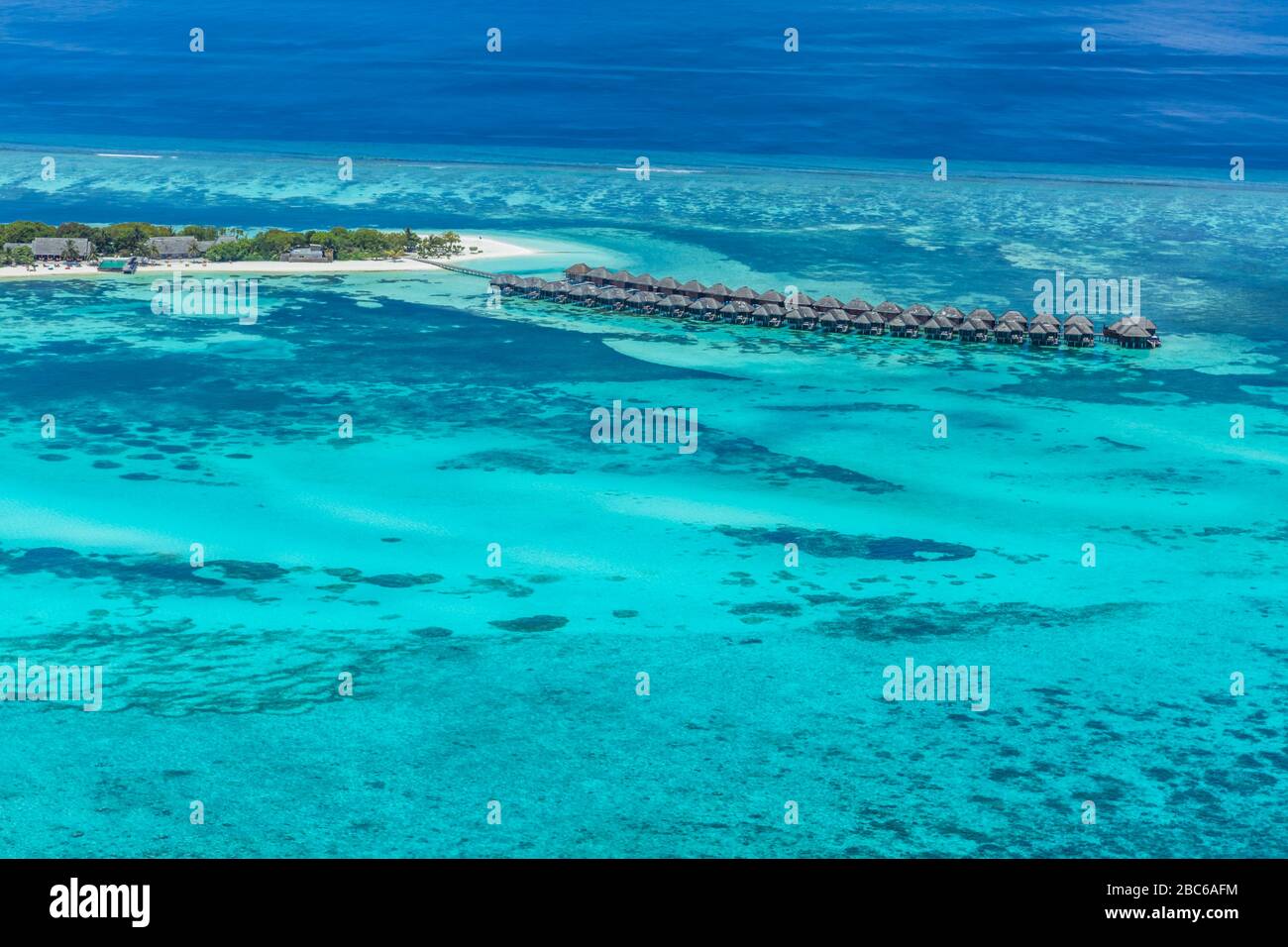 Vista aerea sull'isola delle Maldive. Ville di lusso con acqua e spiaggia, bungalow con un paesaggio meraviglioso natura. Viaggi di lusso e vacanze Foto Stock