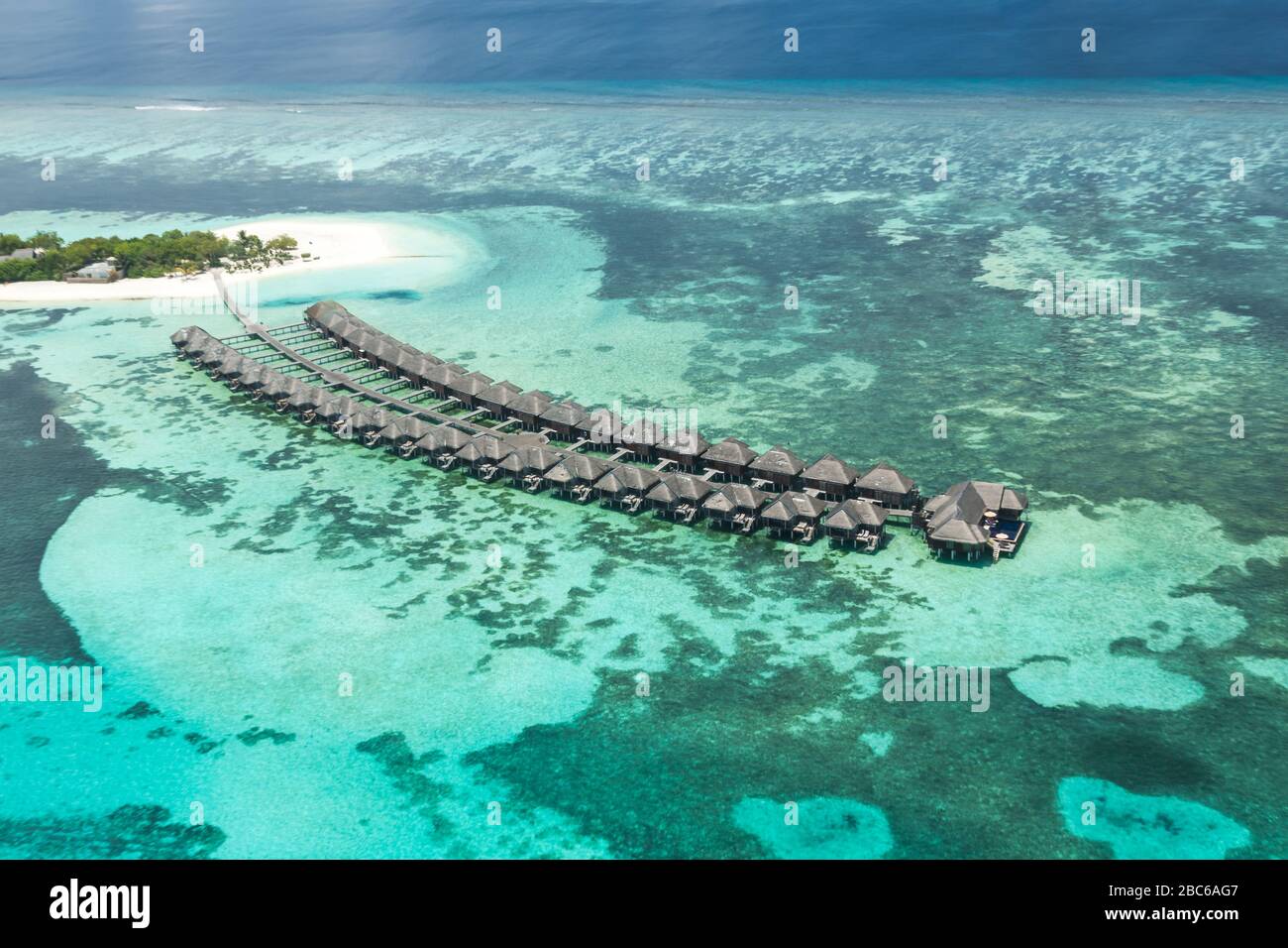 Vista aerea sull'isola delle Maldive. Ville di lusso con acqua e spiaggia, bungalow con un paesaggio meraviglioso natura. Viaggi di lusso e vacanze Foto Stock