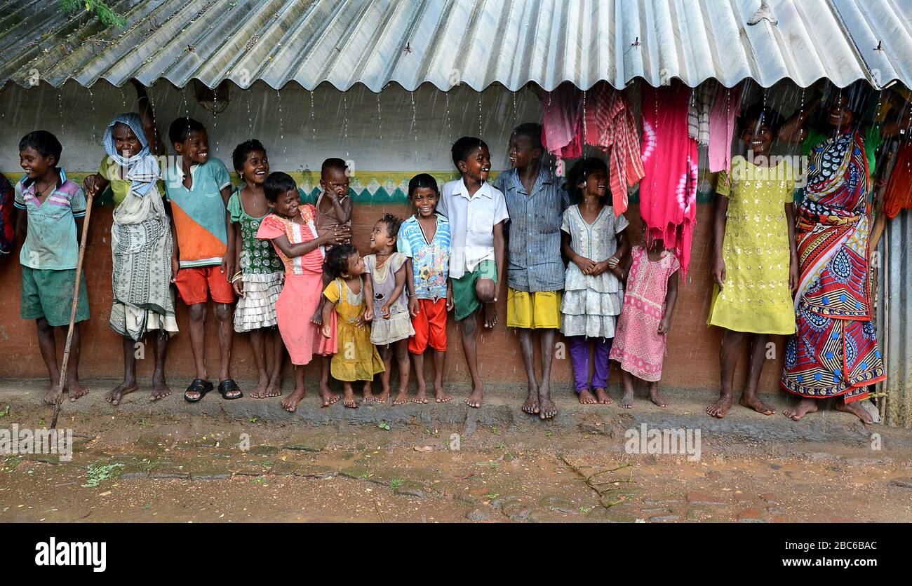 I bambini remoti del villaggio si stanno radunando davanti alla loro casa nel tempo piovoso. Foto Stock