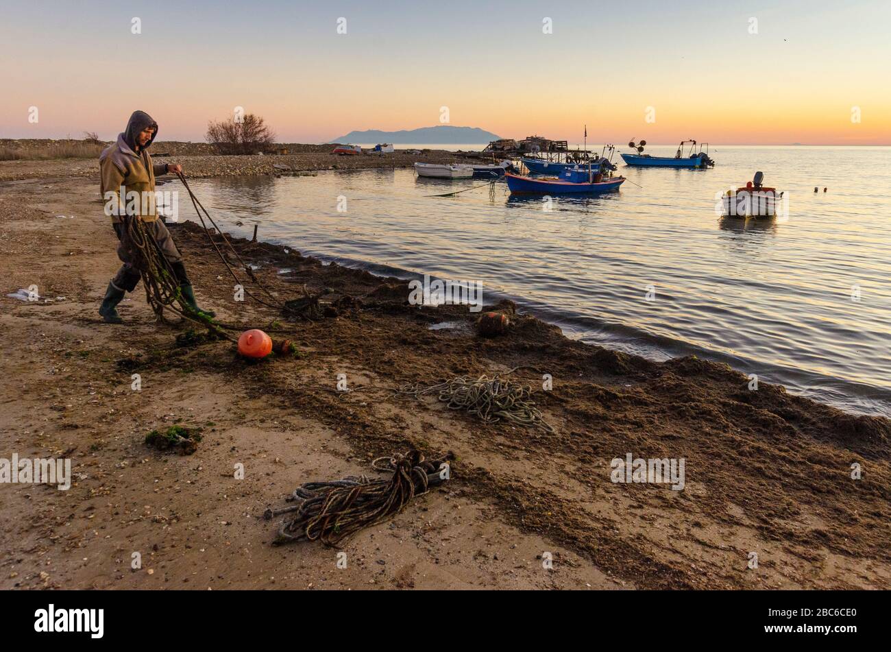 Un pescatore elimina vecchie corde e danni dalla spiaggia di Alexandroupoli Evros Grecia Foto Stock