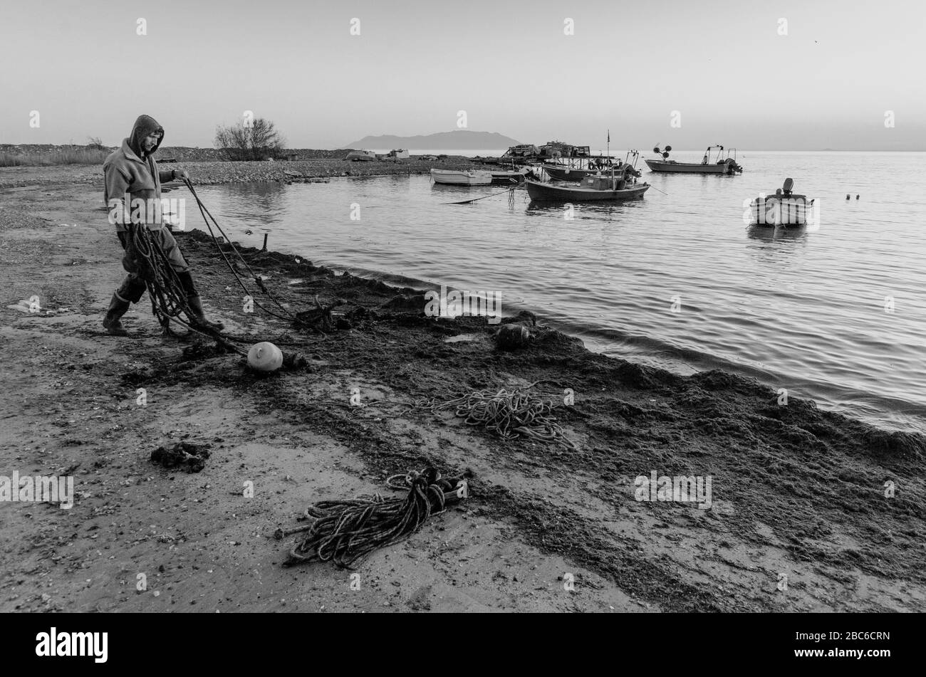 Un pescatore elimina vecchie corde e danni dalla spiaggia di Alexandroupoli Evros Grecia Foto Stock